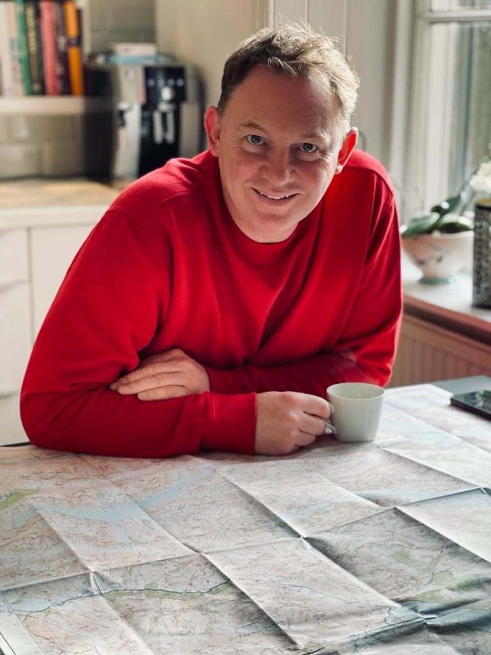 Rodi McLean, founder of Form Design Consultants, relaxes with a map and coffee in a sustainable workspace.