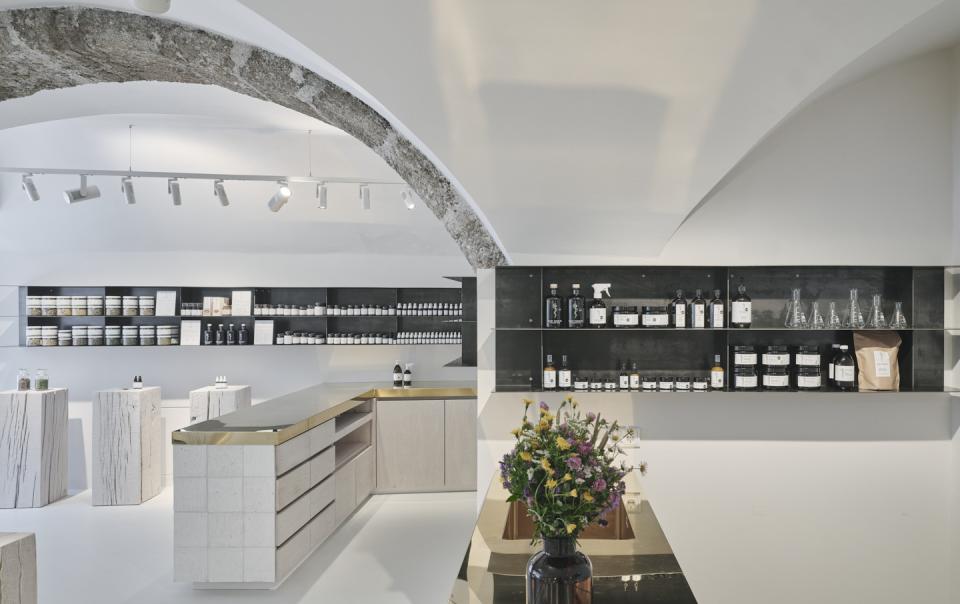 Elegant interior of Saint Charles' Salzburg store showcasing natural cosmetics, stylish displays, and a floral arrangement.