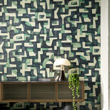 Geometric wallcovering featuring abstract shapes in green and black tones, complemented by modern decor elements.