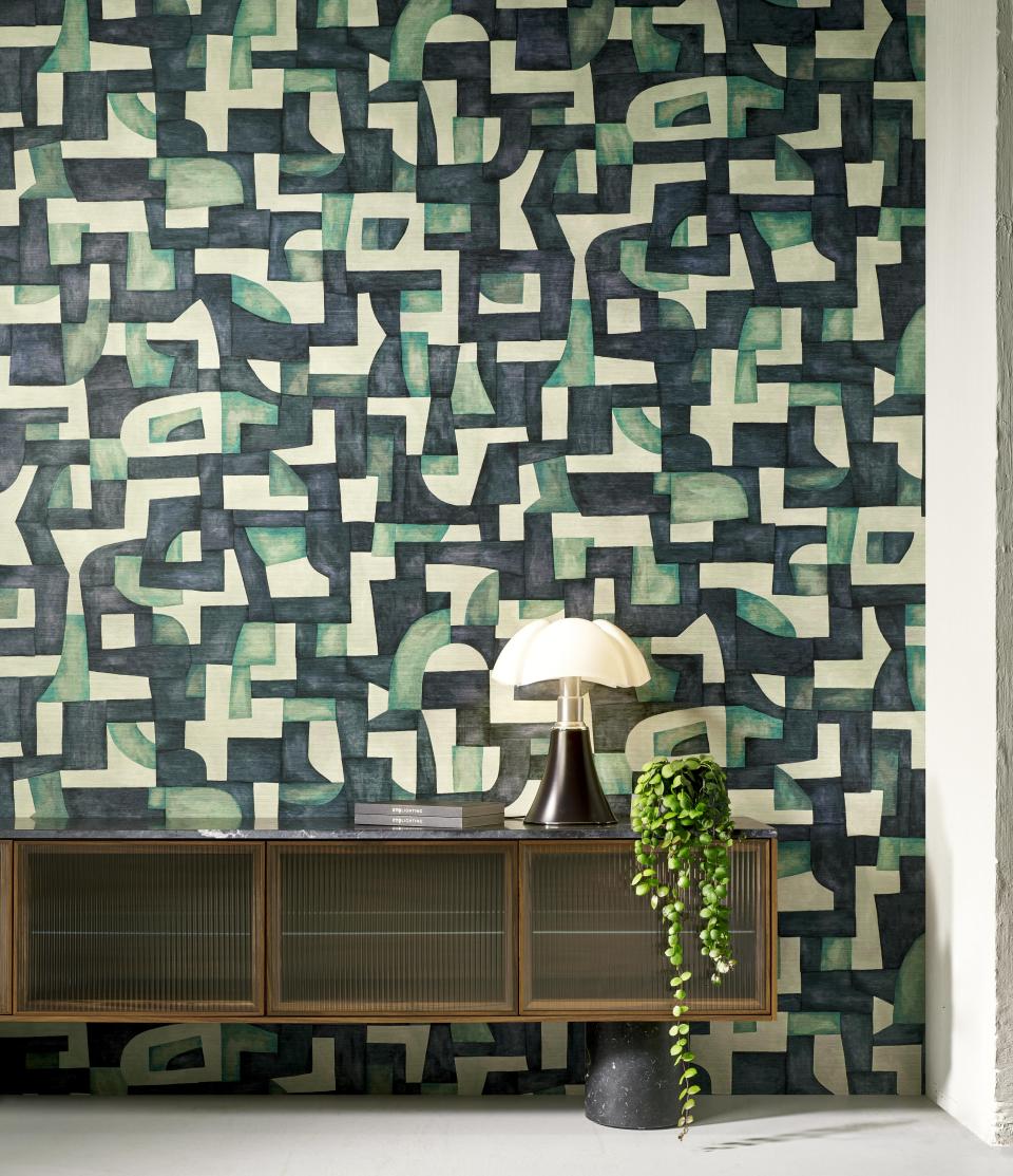Geometric wallcovering featuring abstract shapes in green and black tones, complemented by modern decor elements.