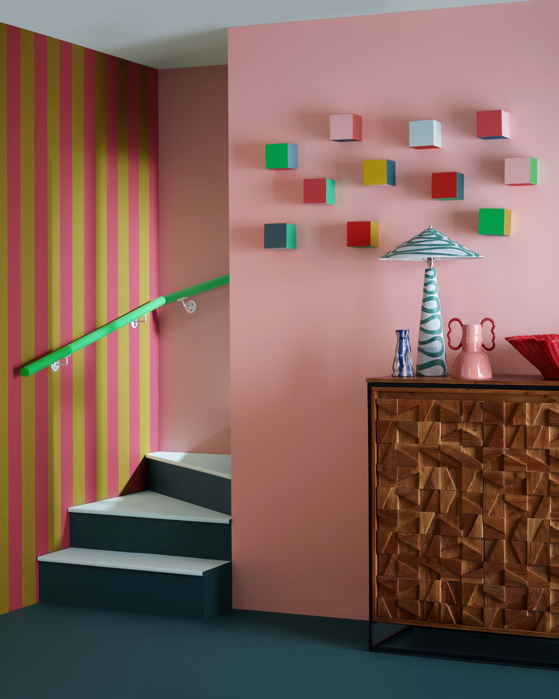Colorful interior design featuring a staircase, vibrant wall art, and decorative furniture, showcasing Crown Paints' Colour Insights for 2024/25.