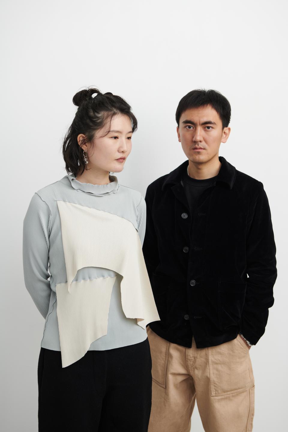 Zhekai Zhang and a collaborator pose in contemporary fashion showcasing innovative textiles, emphasizing sustainable design practices.