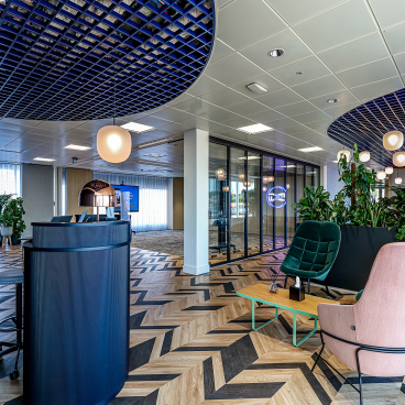 Modern office reception area of Domestic & General, featuring stylish seating, greenery, and contemporary design elements.