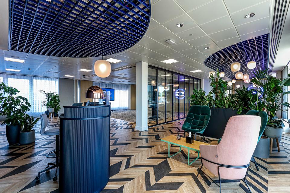 Modern office reception area of Domestic & General, featuring stylish seating, greenery, and contemporary design elements.