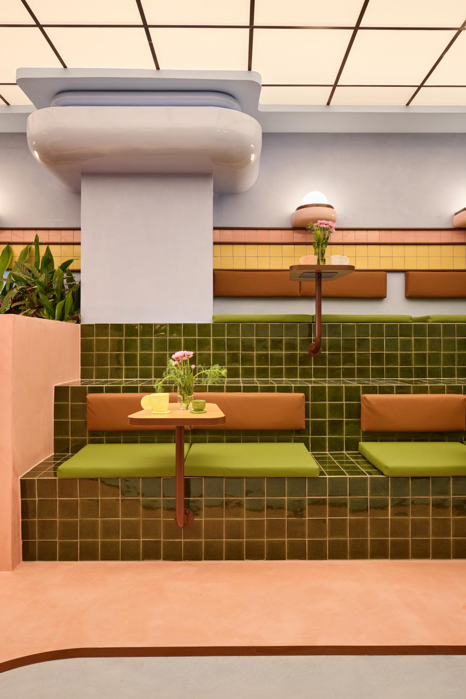 Vibrant interior of a Barcelona ice cream parlour featuring green tiled seating and colorful decor inspired by Miami Art Deco.