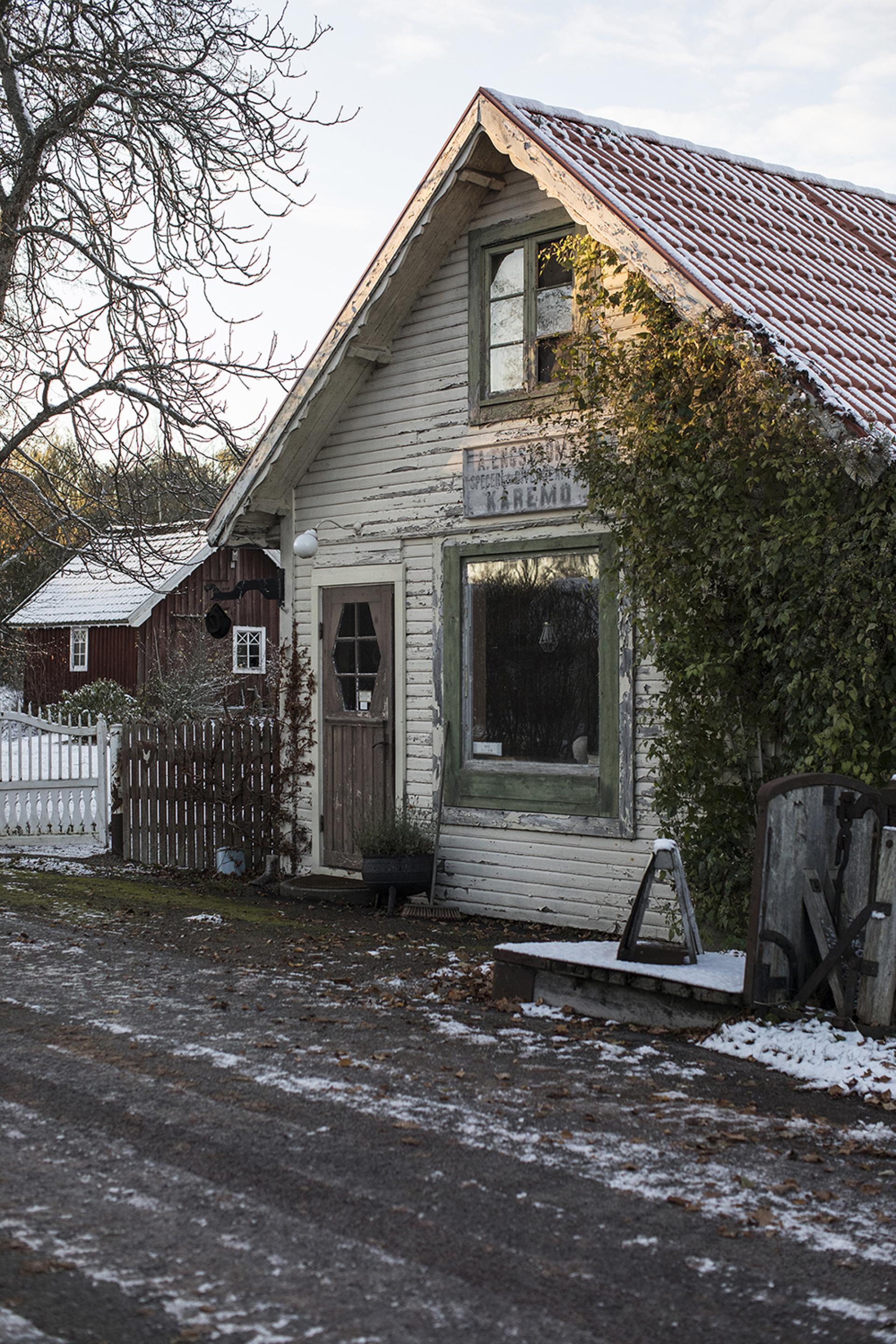 Charming workshop exterior of Horisaki hatmakers in Småland, surrounded by winter foliage and rustic scenery.