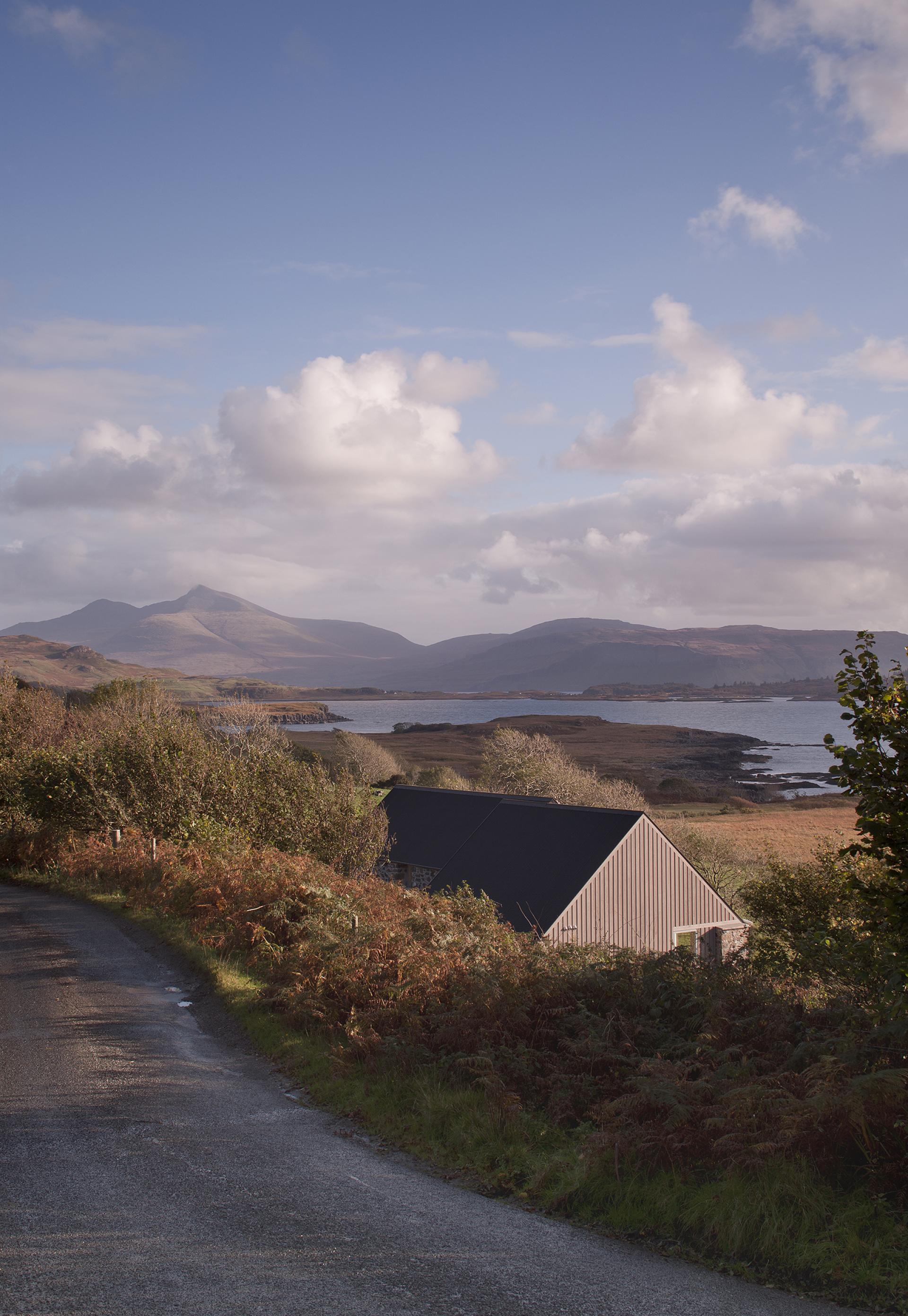 Restored croft on the Isle of Mull, showcasing sustainable architecture amid scenic mountainous landscape and coastal views.