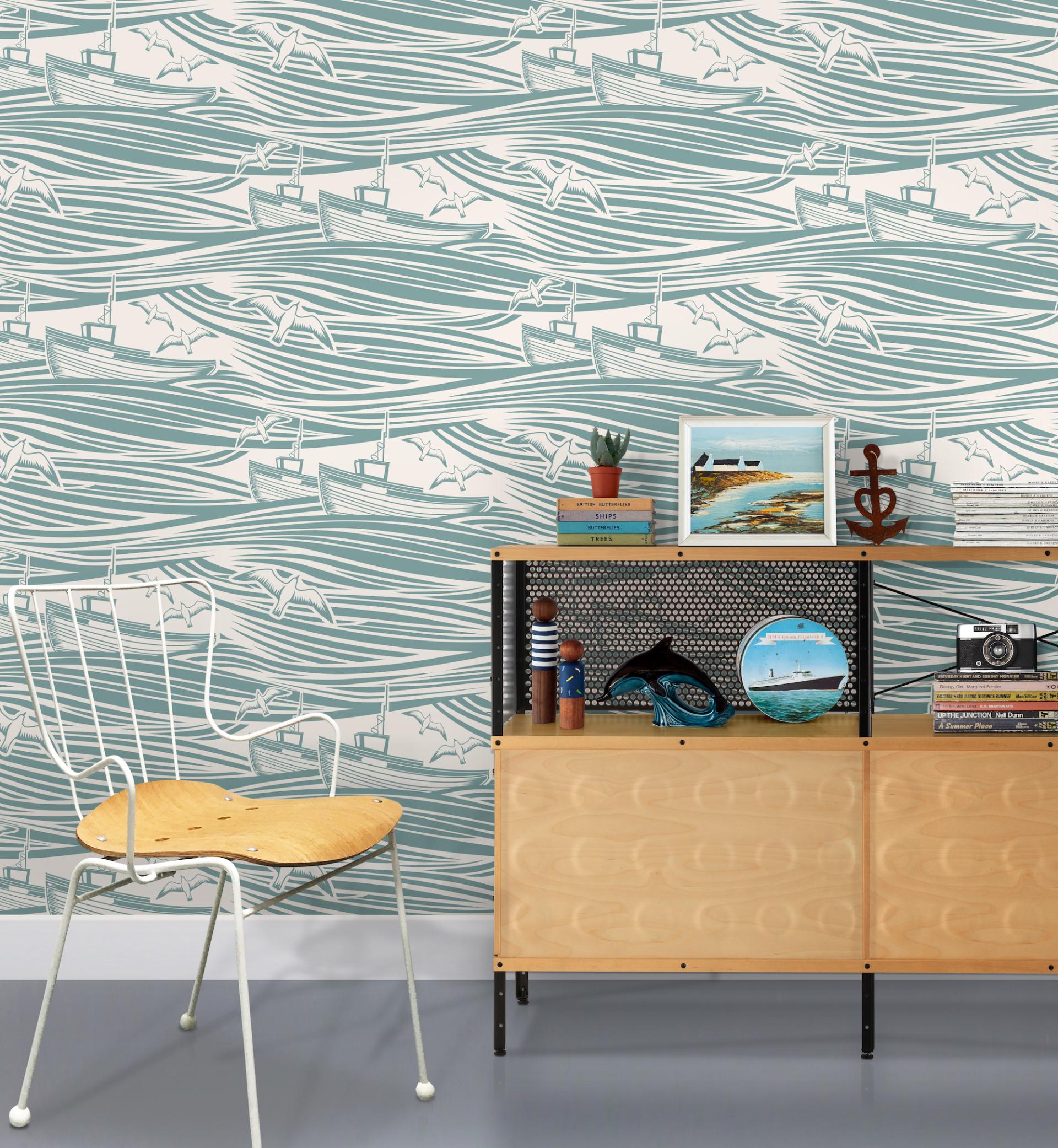 Coastal-inspired wallpaper featuring boats and waves, complemented by stylish decor and a chair in a modern setting.