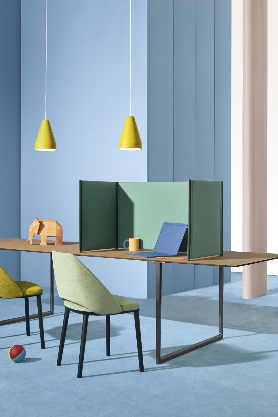 Stylish home office workstation featuring a desk, green dividers, modern chairs, and decorative elements for remote work.