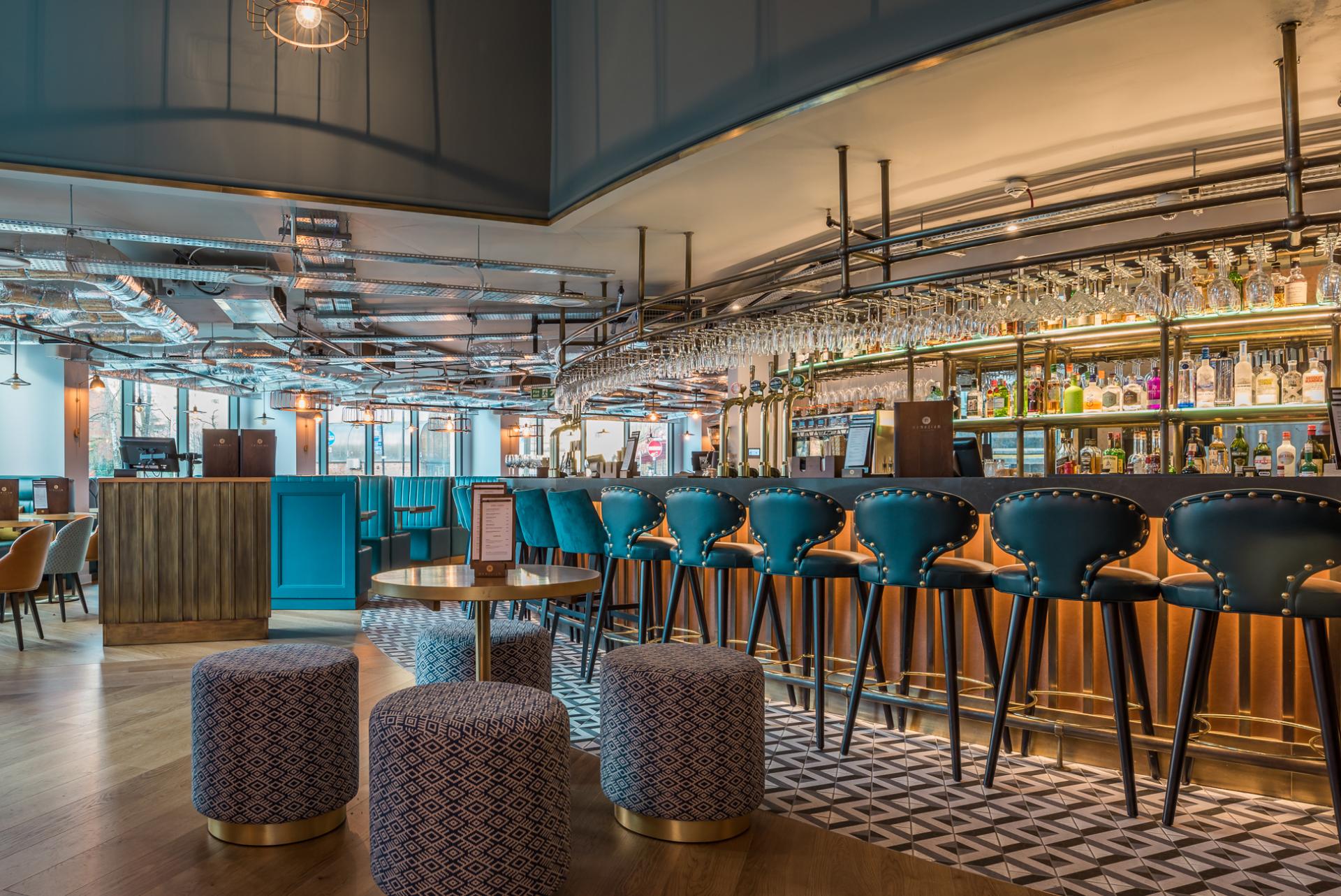 Modern bar interior featuring stylish stools, a vibrant atmosphere, and elegant decor in a Glasgow venue.