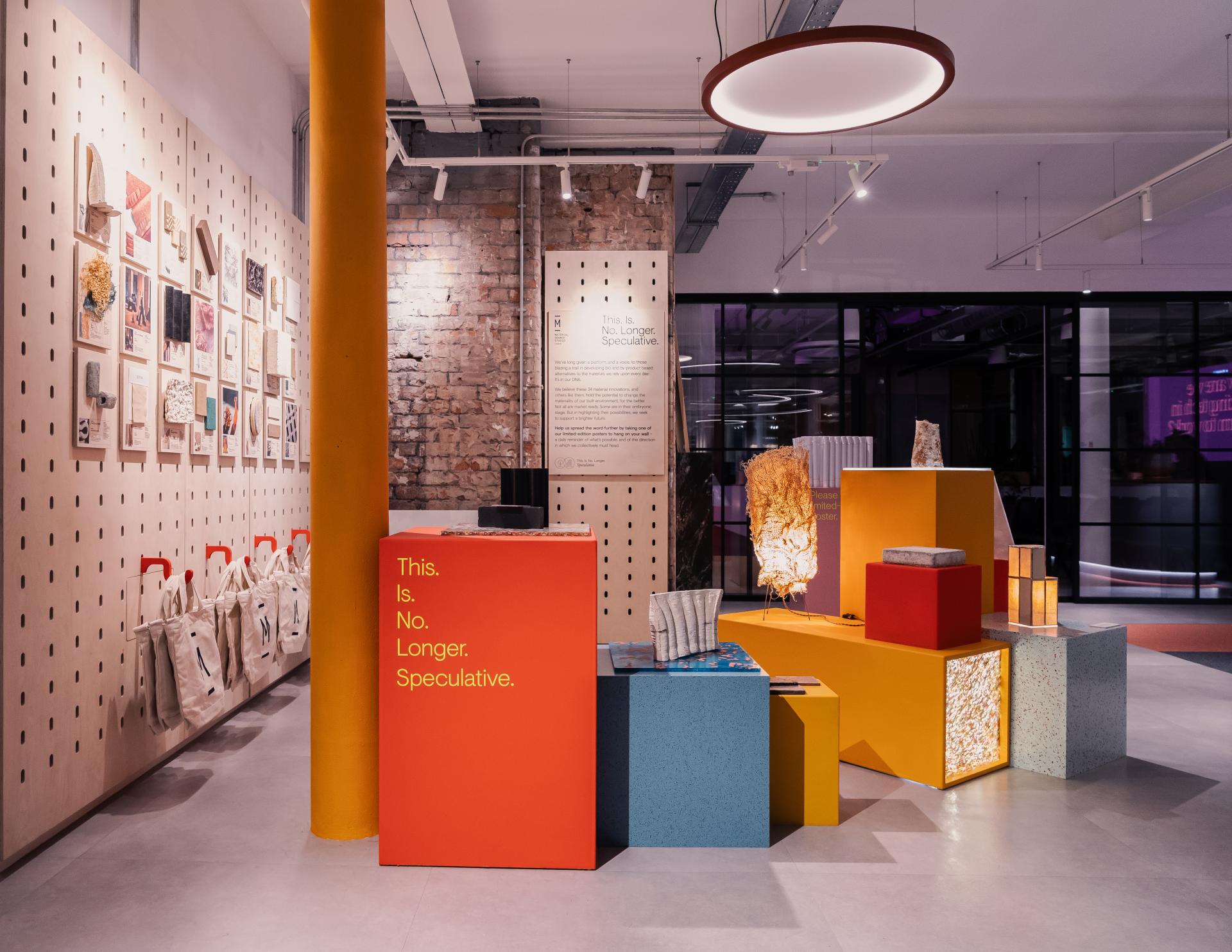 Exhibition space showcasing innovative circular design materials with vibrant display structures and informational signage.