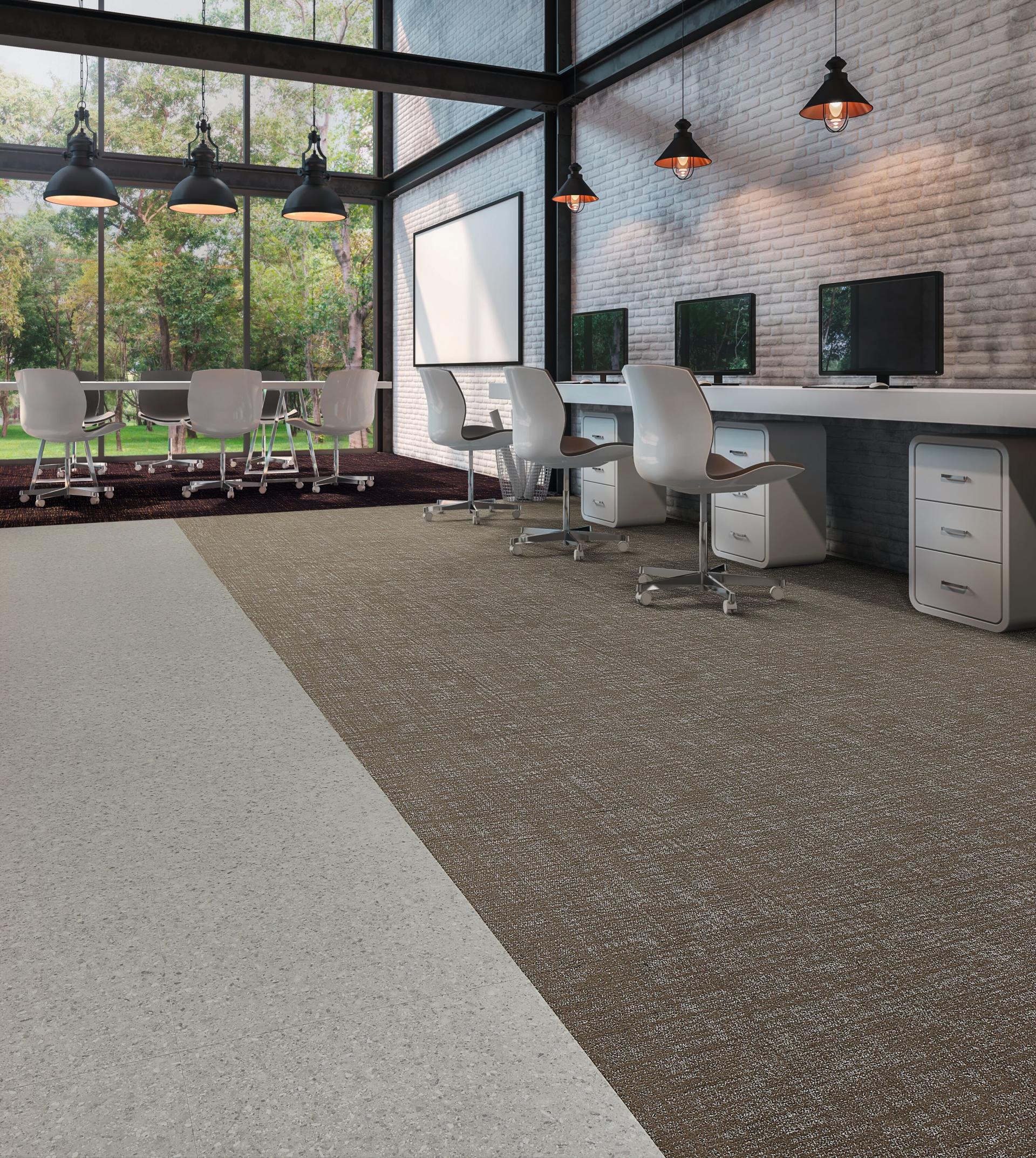 Modern office space featuring luxurious Forbo Flooring Systems, combining textured dual-tone carpet and sleek interiors amidst natural light.