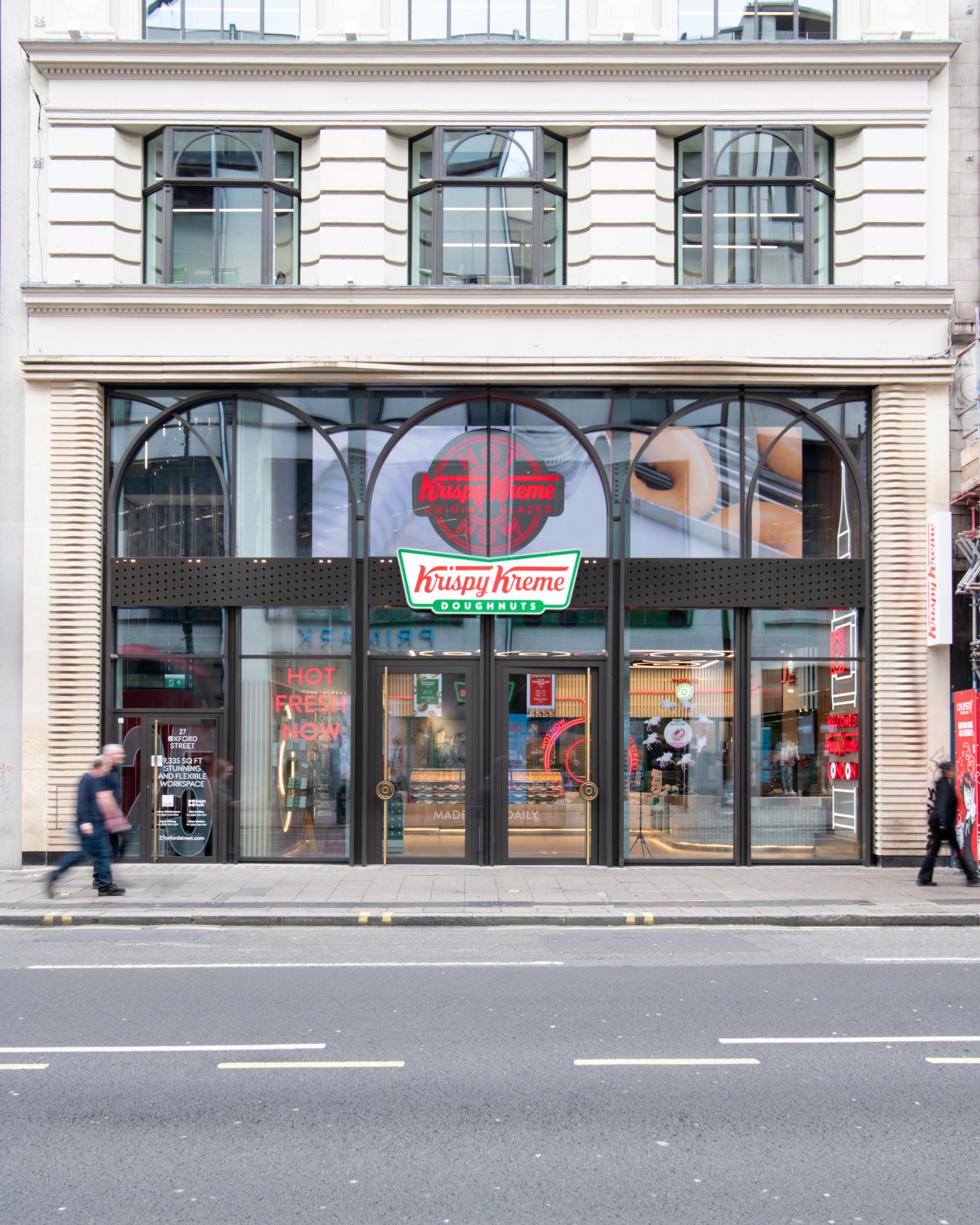 Krispy Kreme's flagship London store features modern design and vibrant signage, inviting customers to enjoy fresh doughnuts.