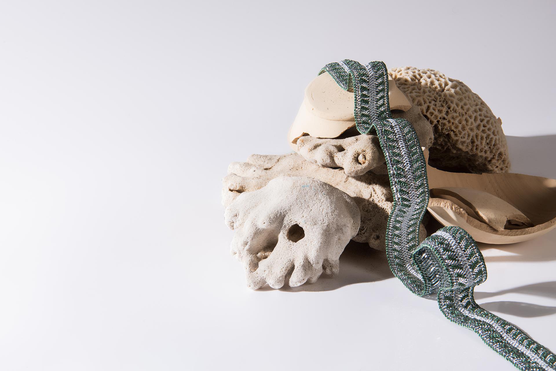 Artistic arrangement of coral and textile elements representing Irthi Contemporary Crafts Council's celebration of women in design.