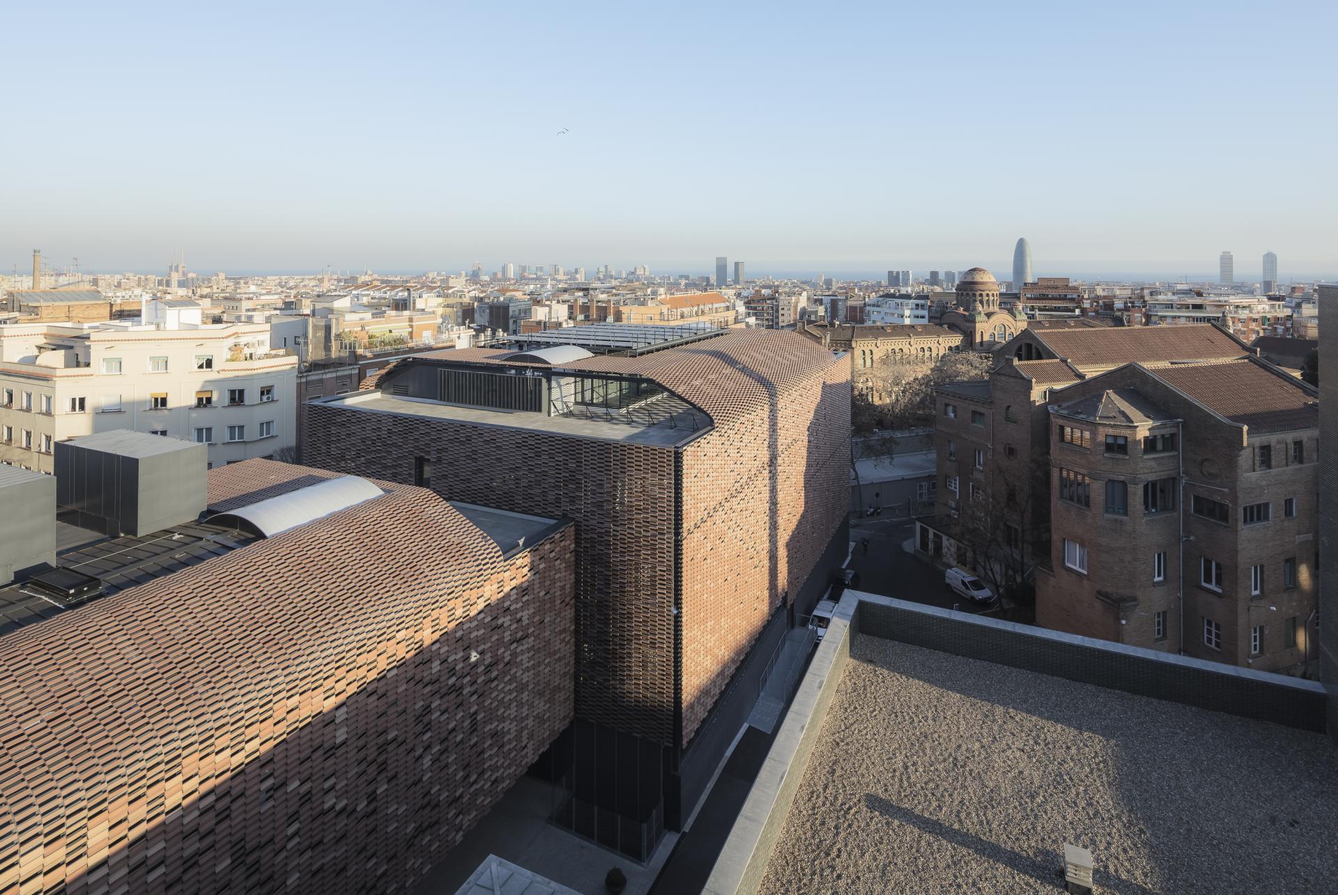 Modern Spanish architecture showcasing innovative use of ceramics and tiles, set against a city skyline.