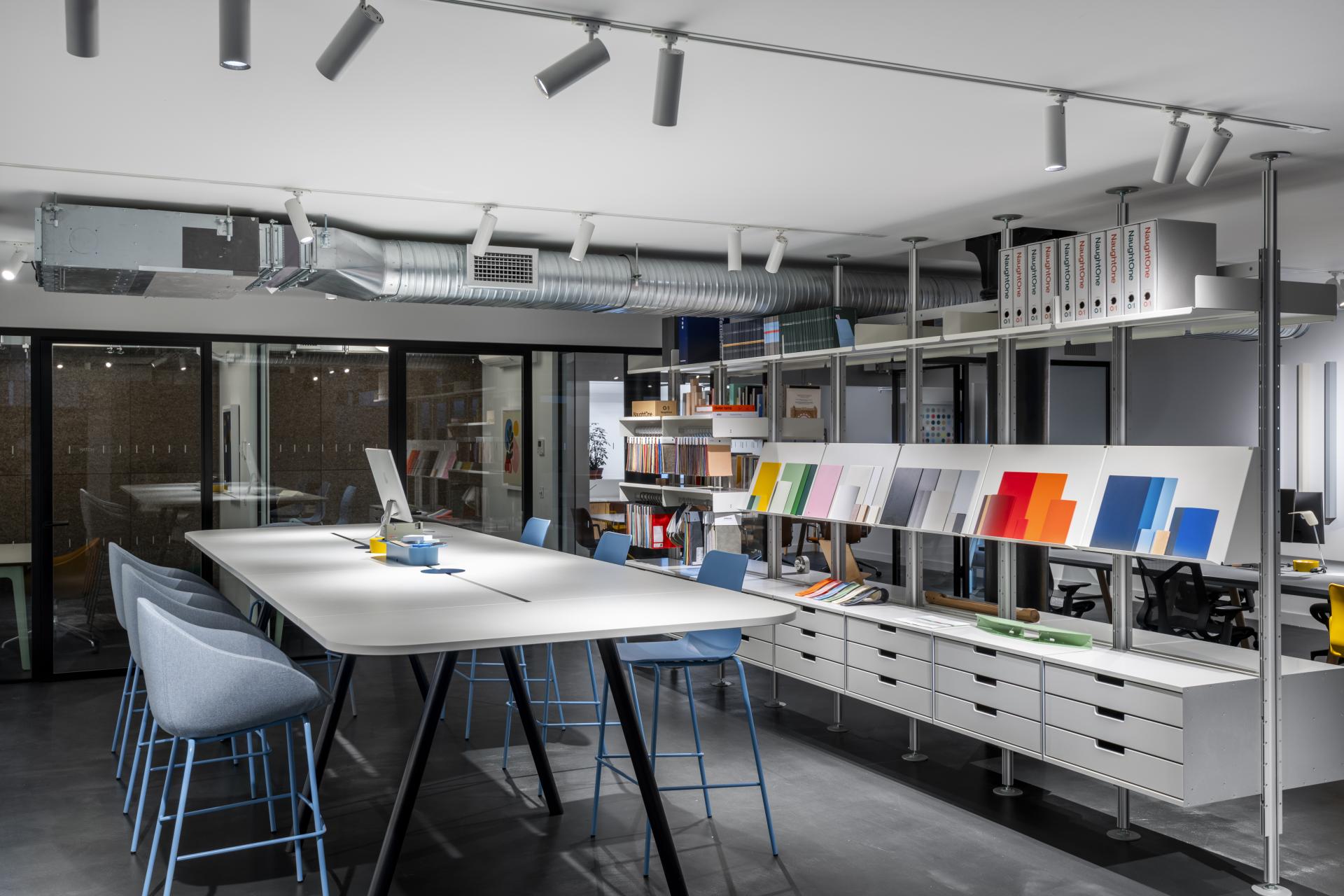 Modern showroom interior featuring workspace furniture and vibrant color samples at NaughtOne's flagship location in London.