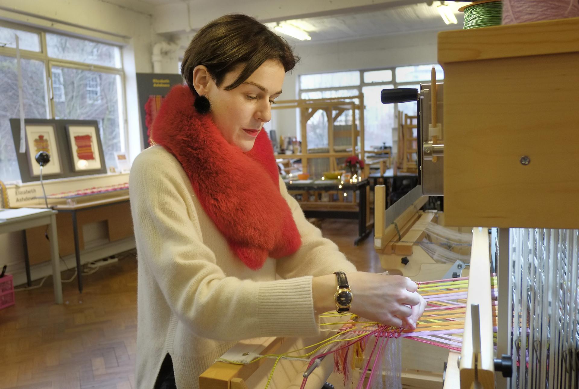 Elizabeth Ashdown expertly weaves colorful passementerie threads in her London studio, showcasing her artistic craftsmanship.