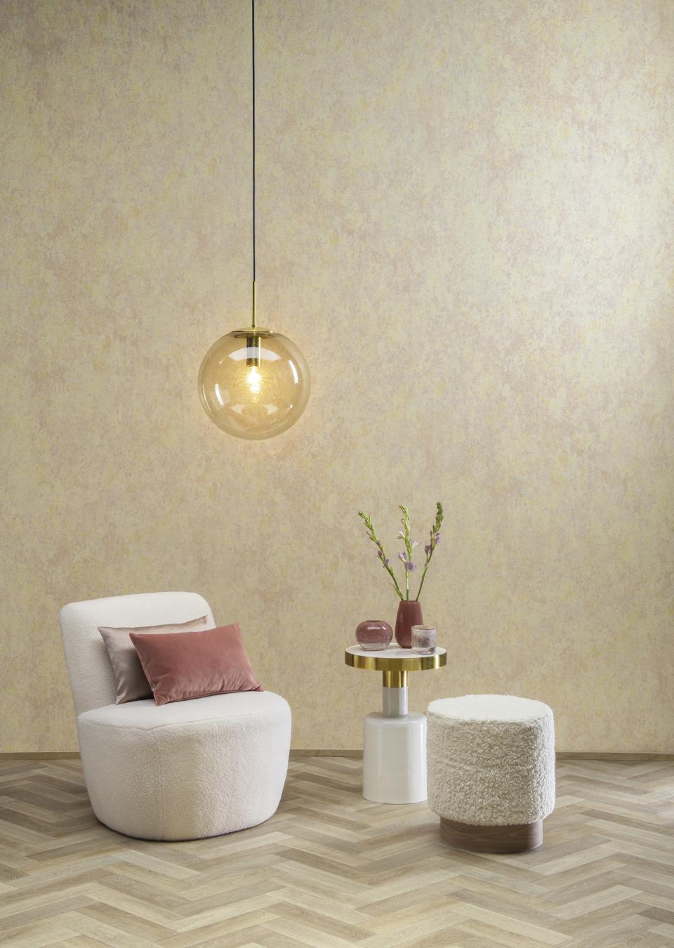 Stylish interior featuring Omexo wallcovering, a cozy chair, decorative table, and modern pendant lighting.