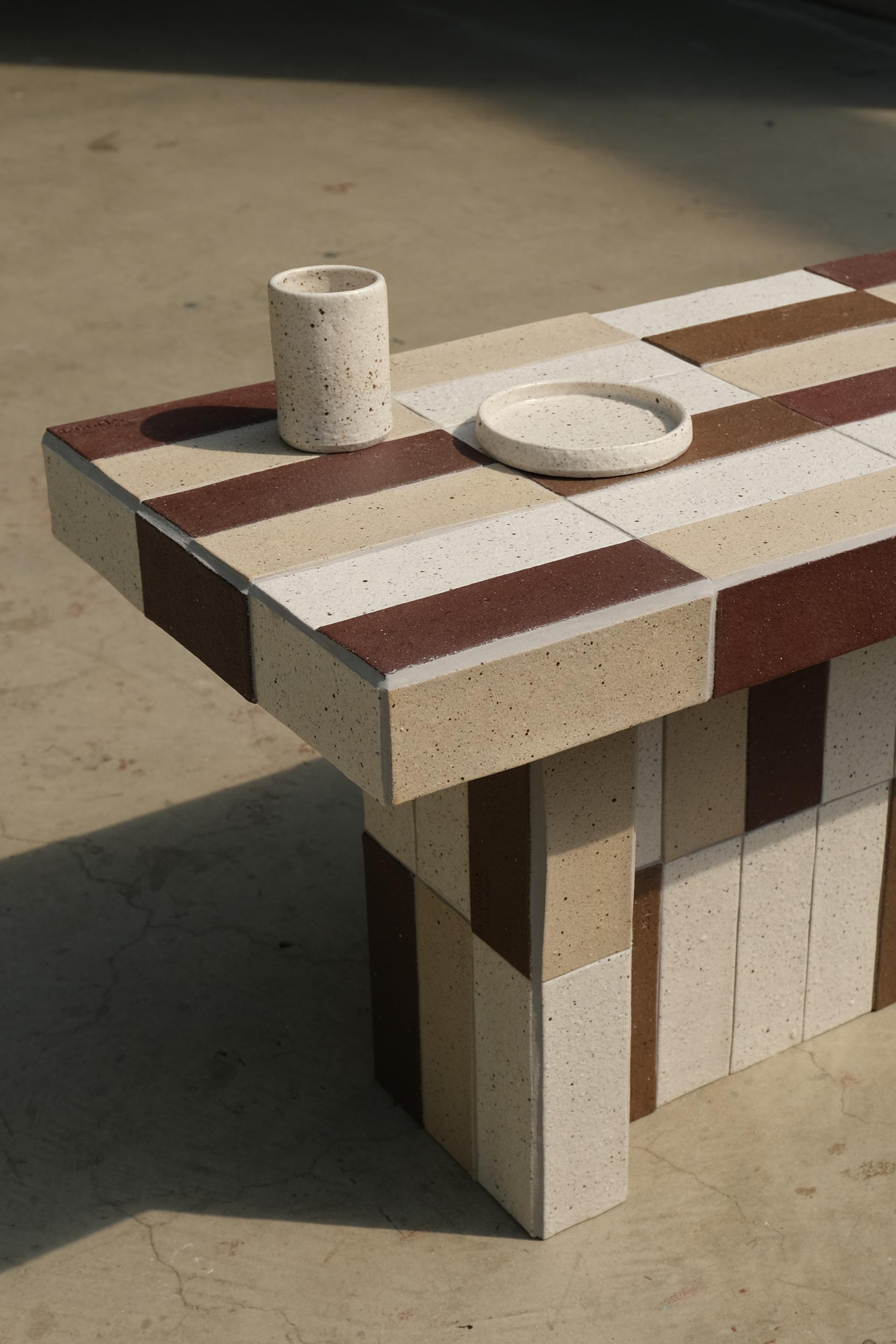 Coffee table made from recycled ceramic and waste materials, showcasing a unique patterned design in earthy tones.