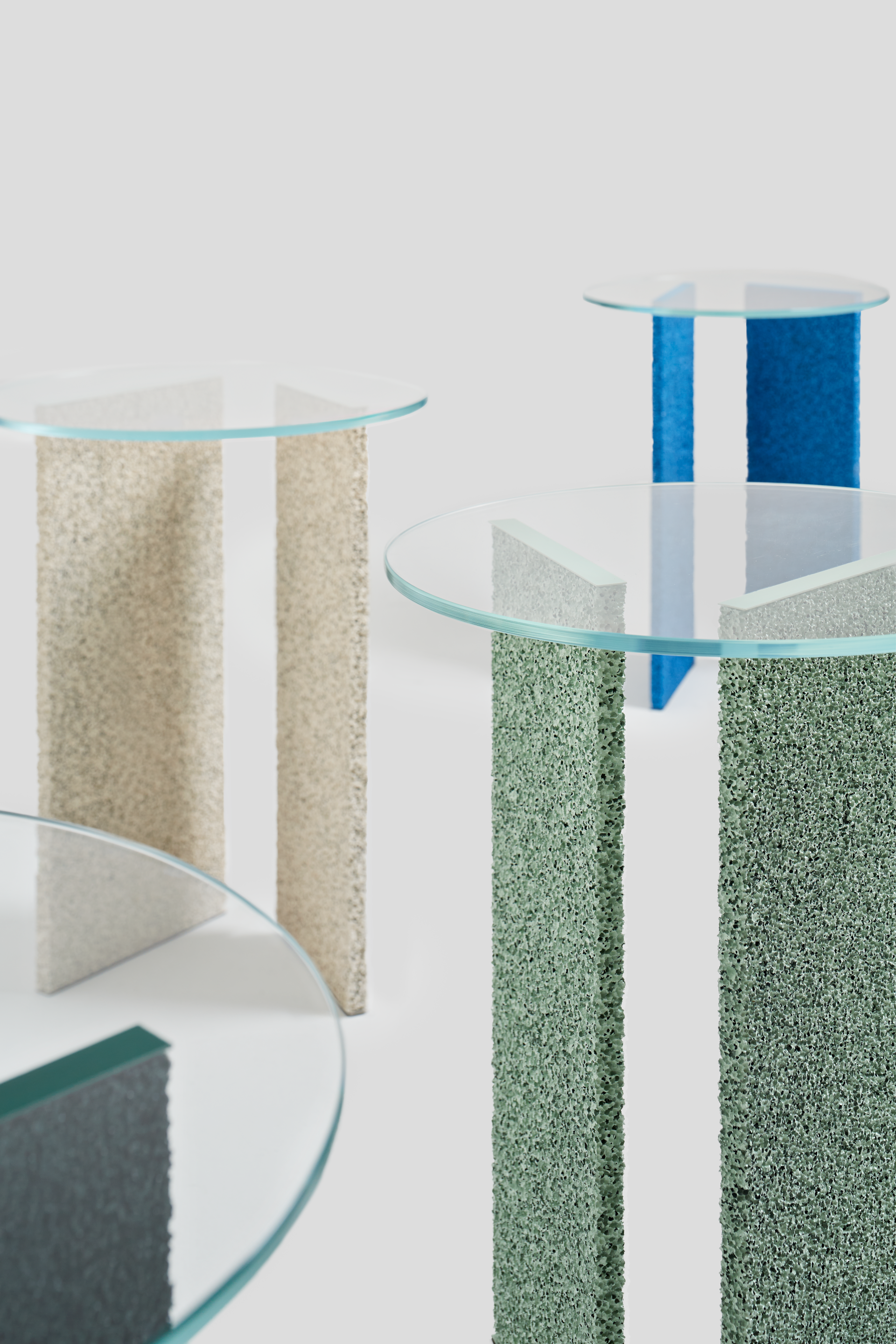 Contemporary tables with colorful textured bases and glass tops featured at London Craft Week 2024 event by Future Icons.