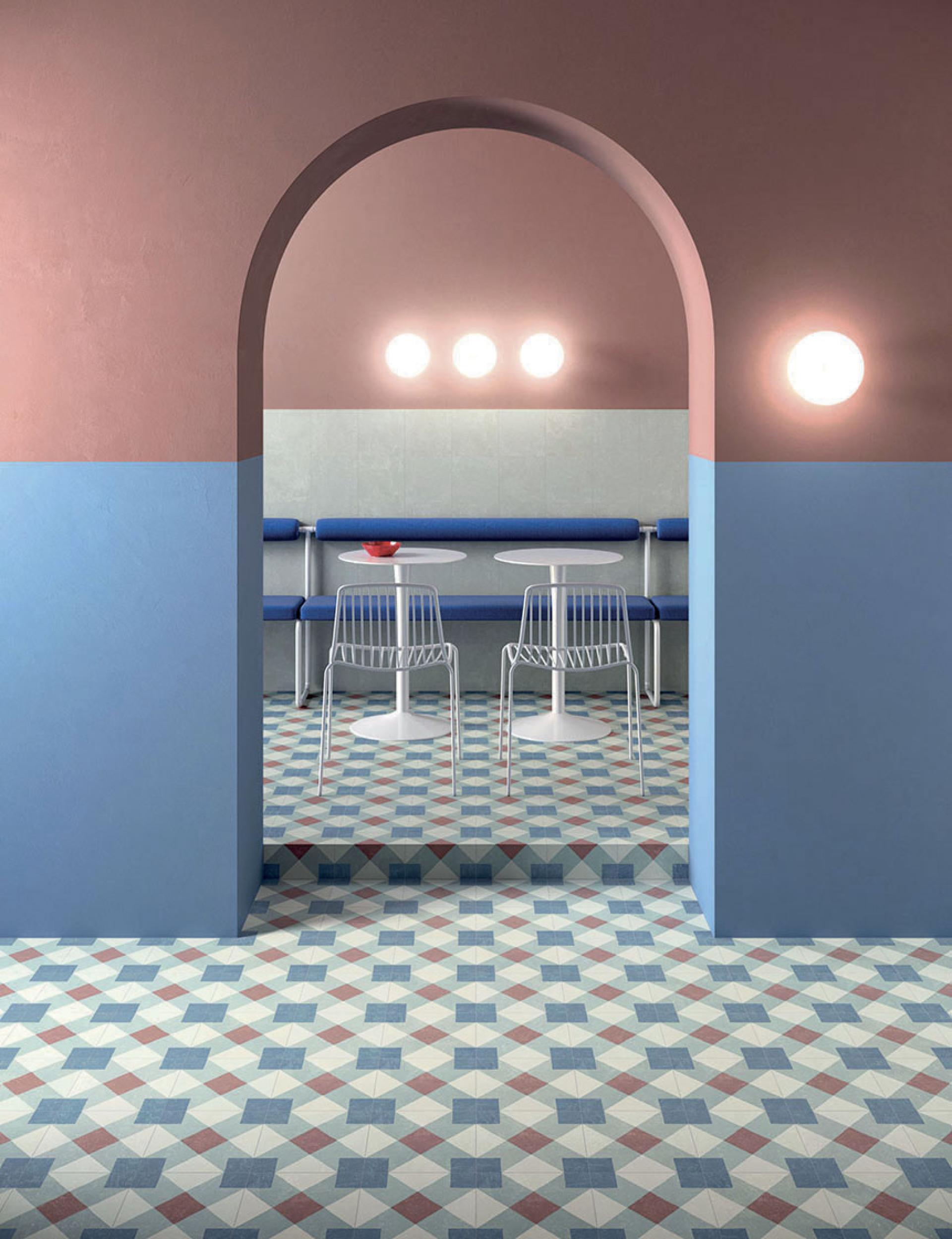 Stylish interior featuring geometric tile flooring, colorful walls, and modern seating, showcasing design trends from CERSAIE 2019.