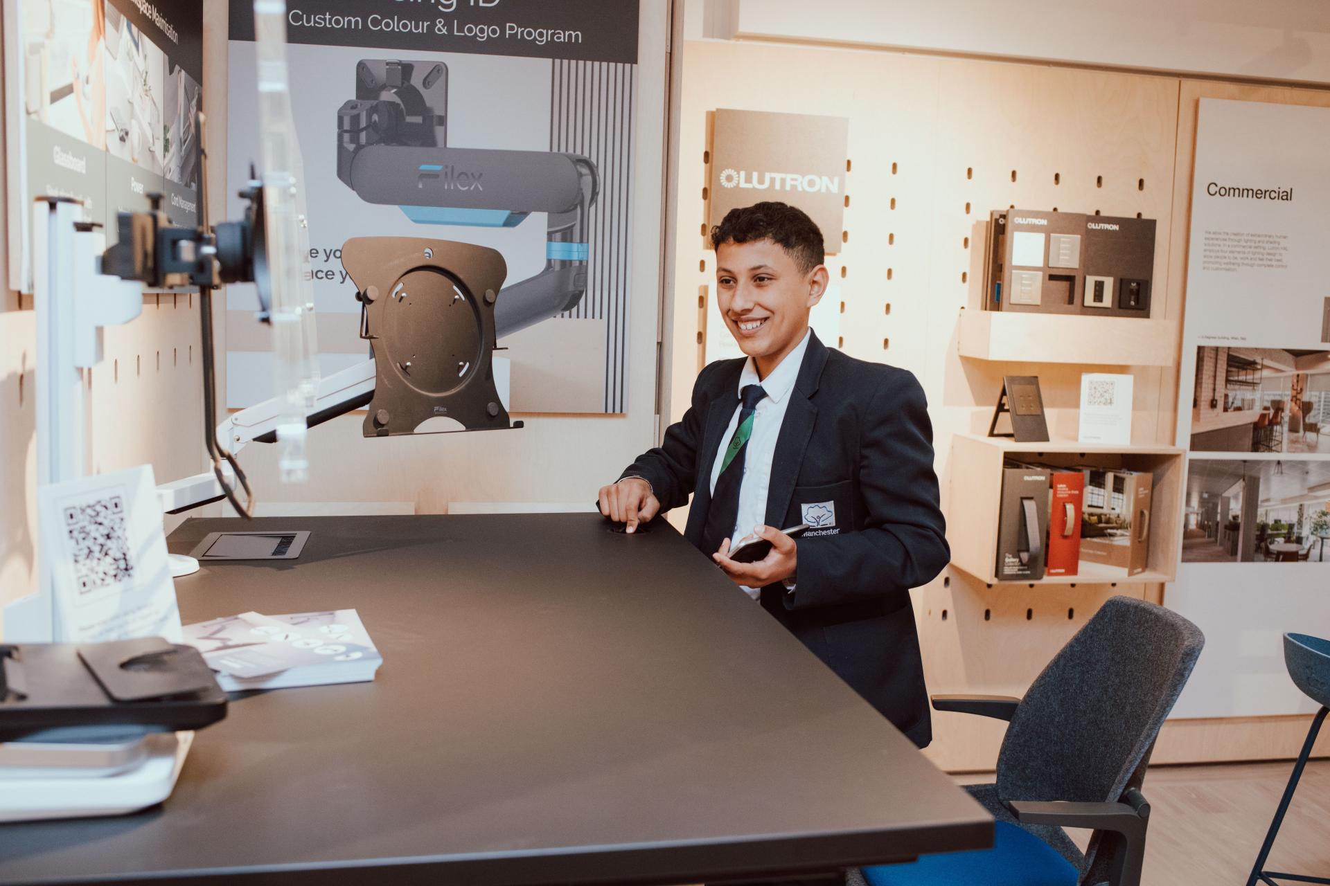 Smiling student in a blazer exploring innovative interior design tools at SCENE Interiors, Manchester Academy.