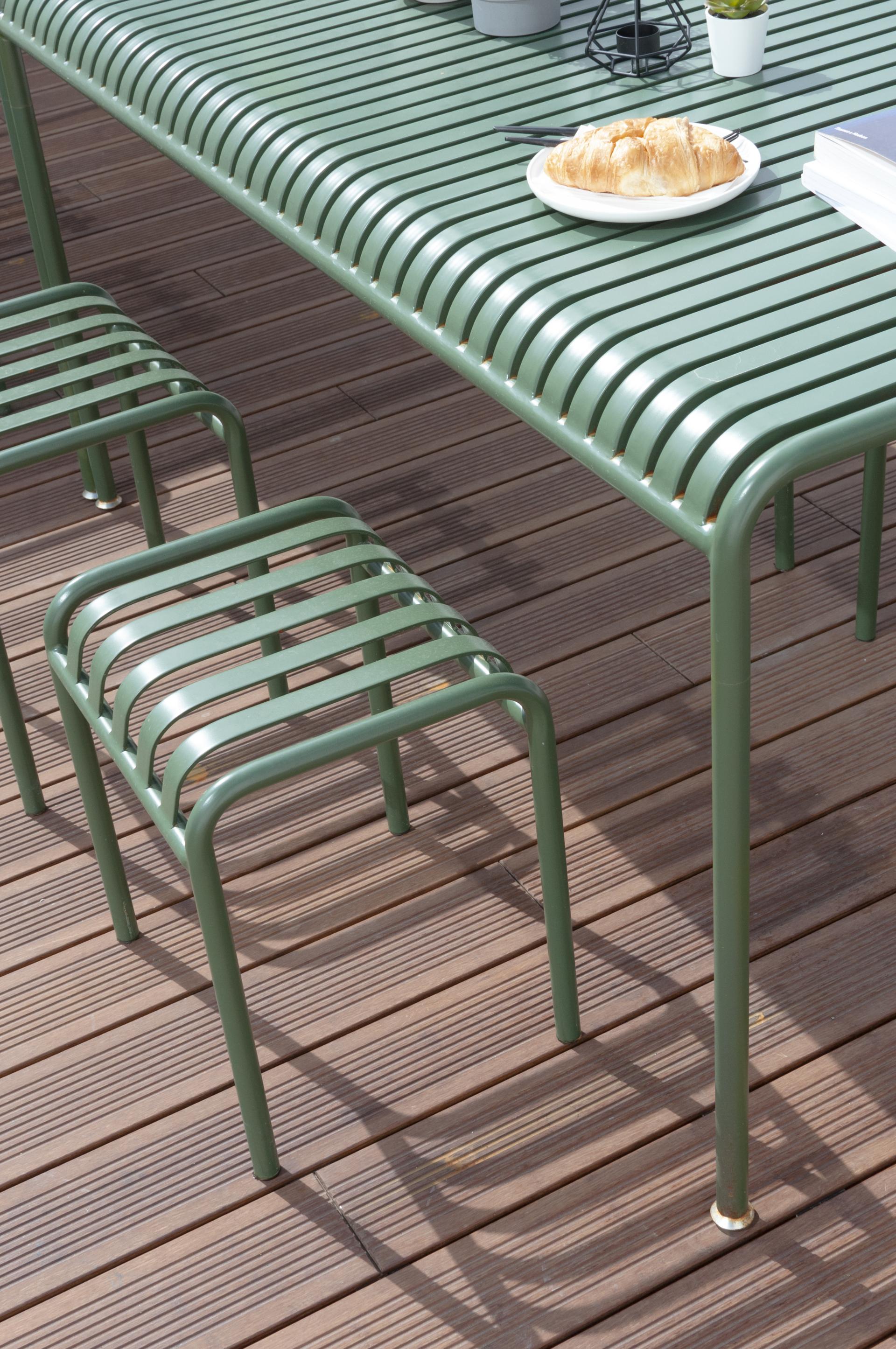 Modern green dining table with minimalist chairs, set on wooden flooring, ideal for contemporary live-work spaces.