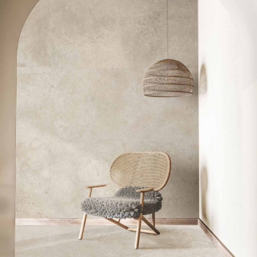 Stylish interior featuring a modern chair, textured wall tiles, and a minimalist pendant light, showcasing contemporary Spanish design trends.