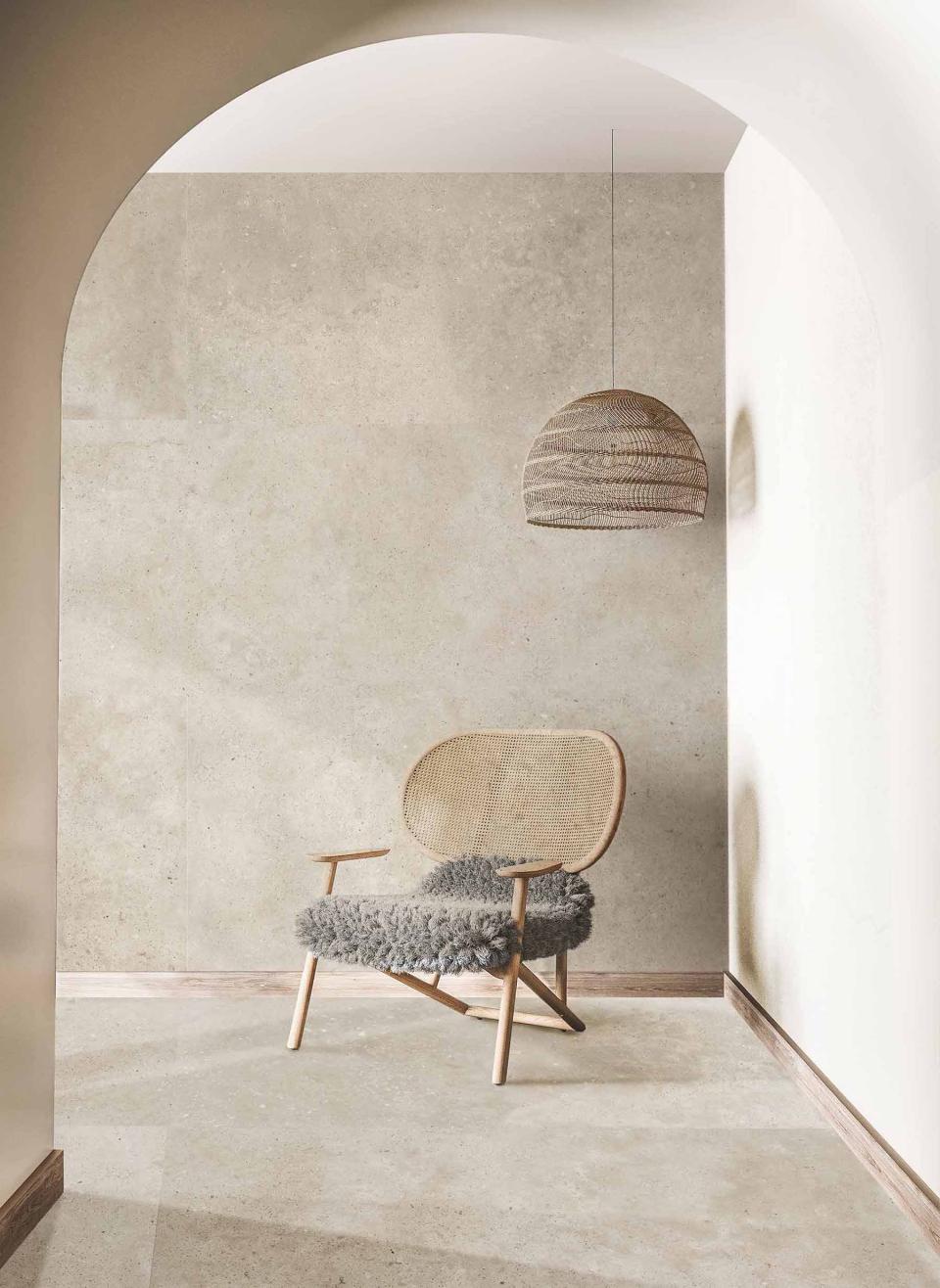 Stylish interior featuring a modern chair, textured wall tiles, and a minimalist pendant light, showcasing contemporary Spanish design trends.
