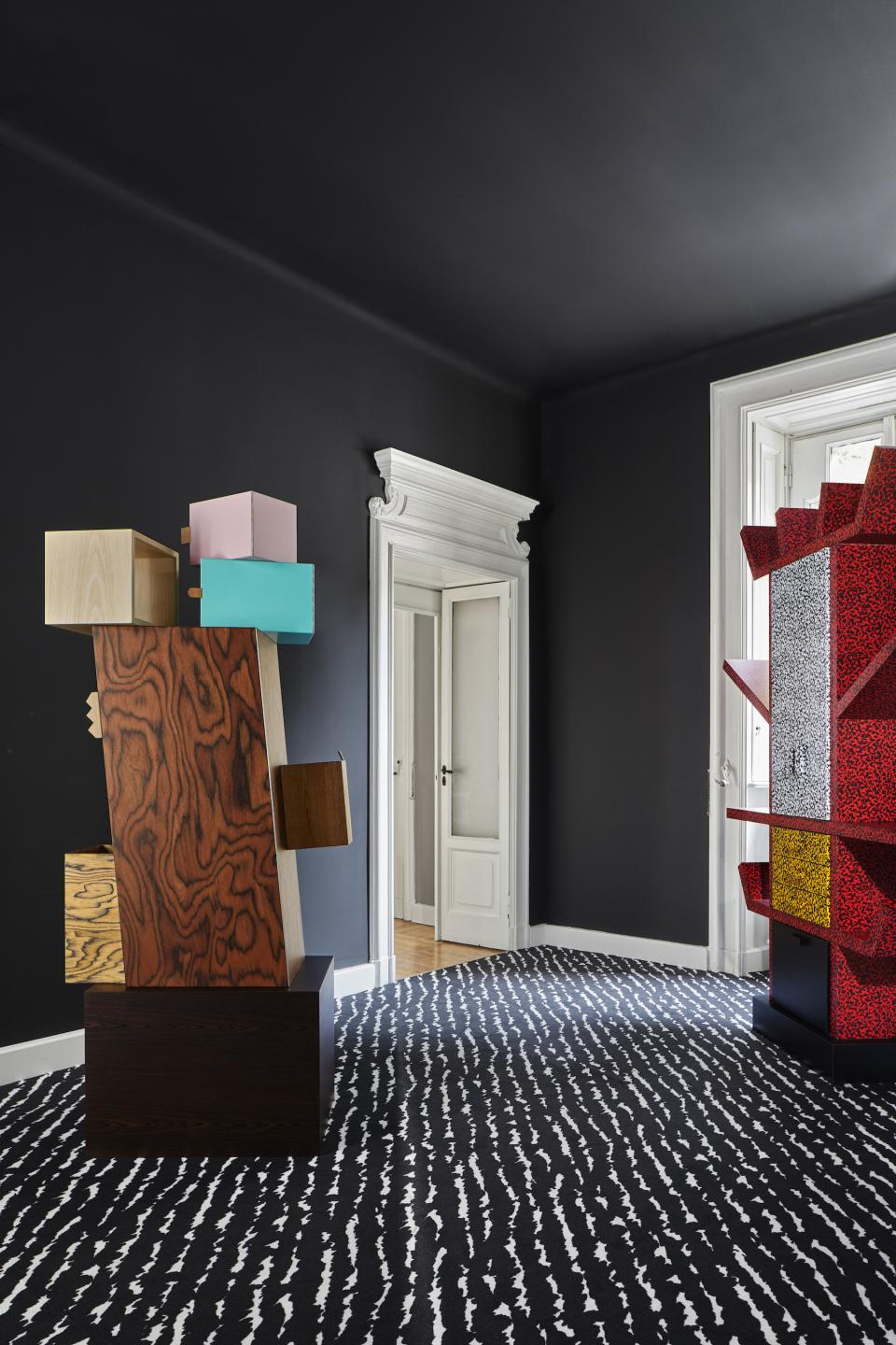 Colorful Memphis Milano furniture stands in a contemporary Brera interior, showcasing unique design and artistic style.