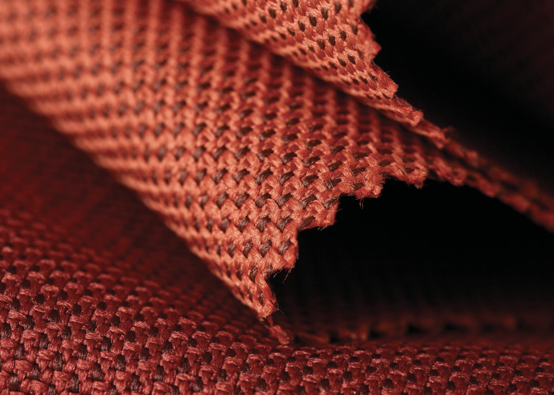 Luxurious, acoustically transparent textile made from recycled plastic bottles in a rich reddish-brown color.