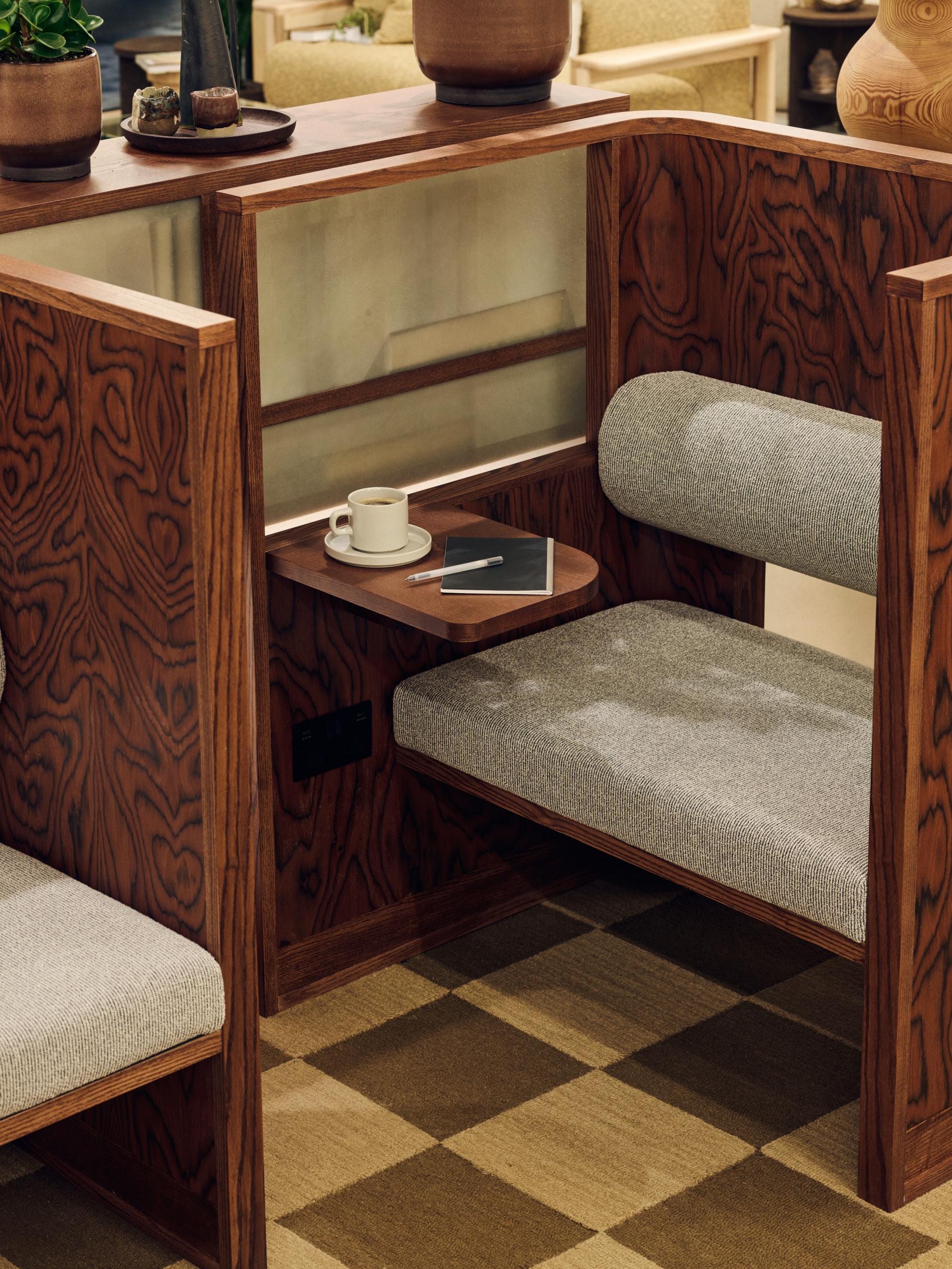 Cozy seating area featuring sustainable timber furniture, a coffee cup, and decorative plants, emphasizing eco-friendly design.