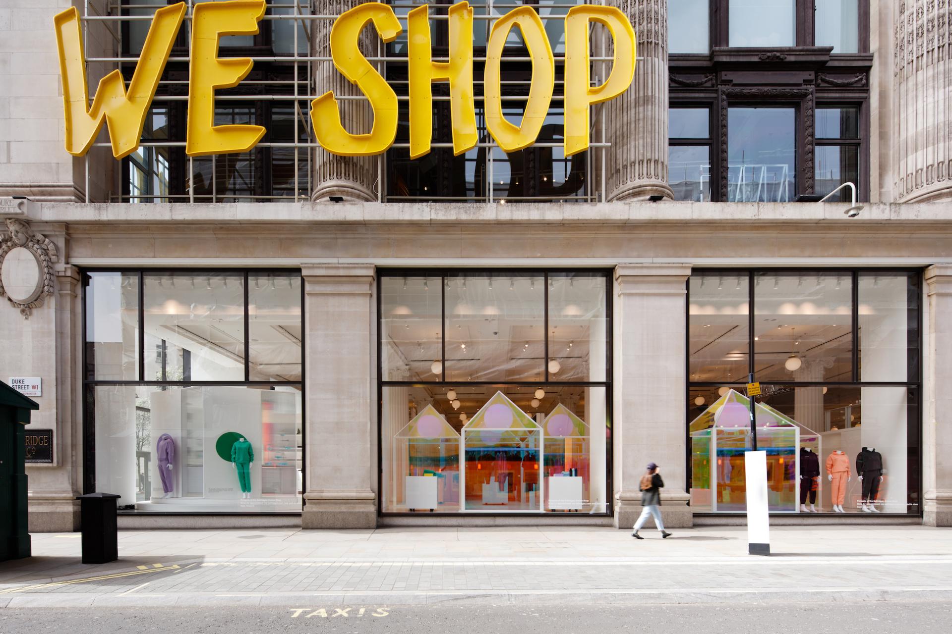 Colorful Pangaia pop-up installation at Selfridges with vibrant fashion displays and bold "WE SHOP" signage.