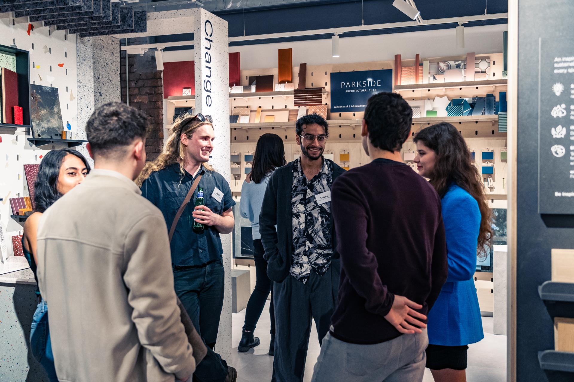 A group of diverse professionals discussing sustainable materials for architecture at an event focused on achieving Net Zero.