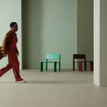 A person walks through a contemporary interior featuring Forbo's Marmoleum Solids collection and colorful chairs.
