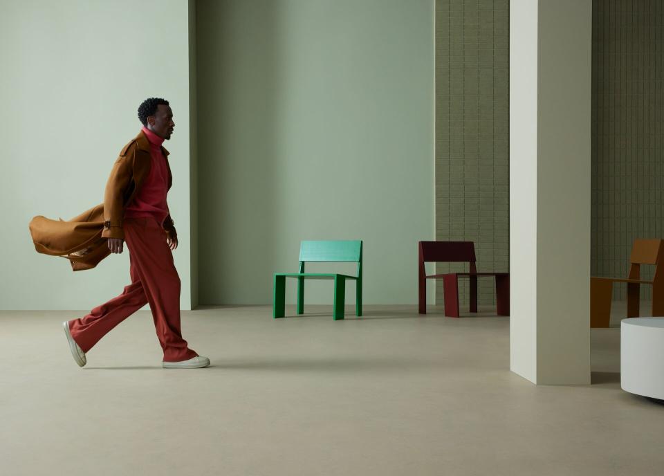 A person walks through a contemporary interior featuring Forbo's Marmoleum Solids collection and colorful chairs.