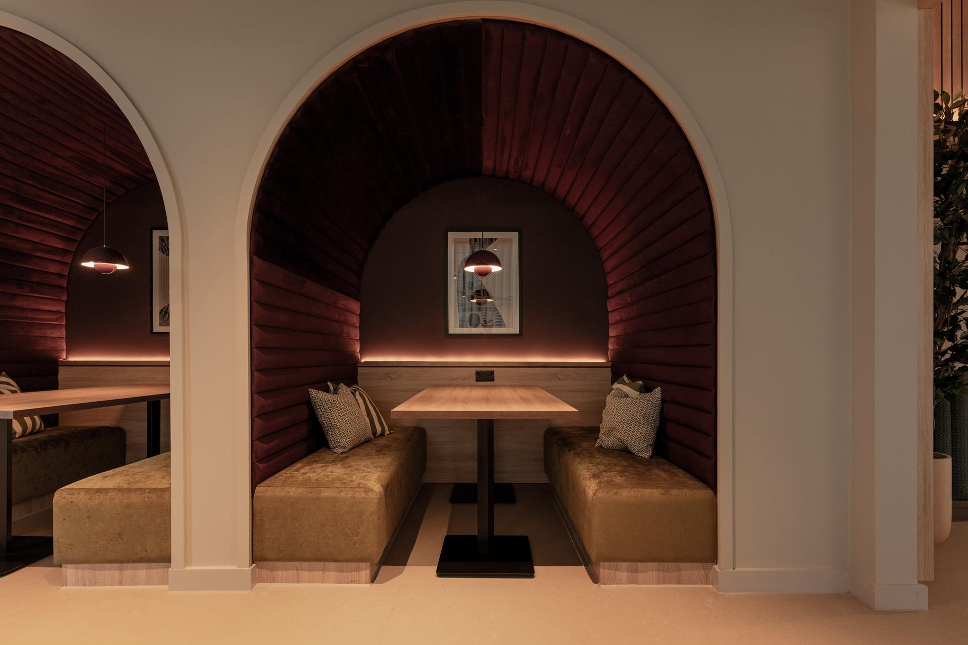 Sophisticated interior seating area featuring textured burgundy arches and modern furnishings at The Place, Nottingham.