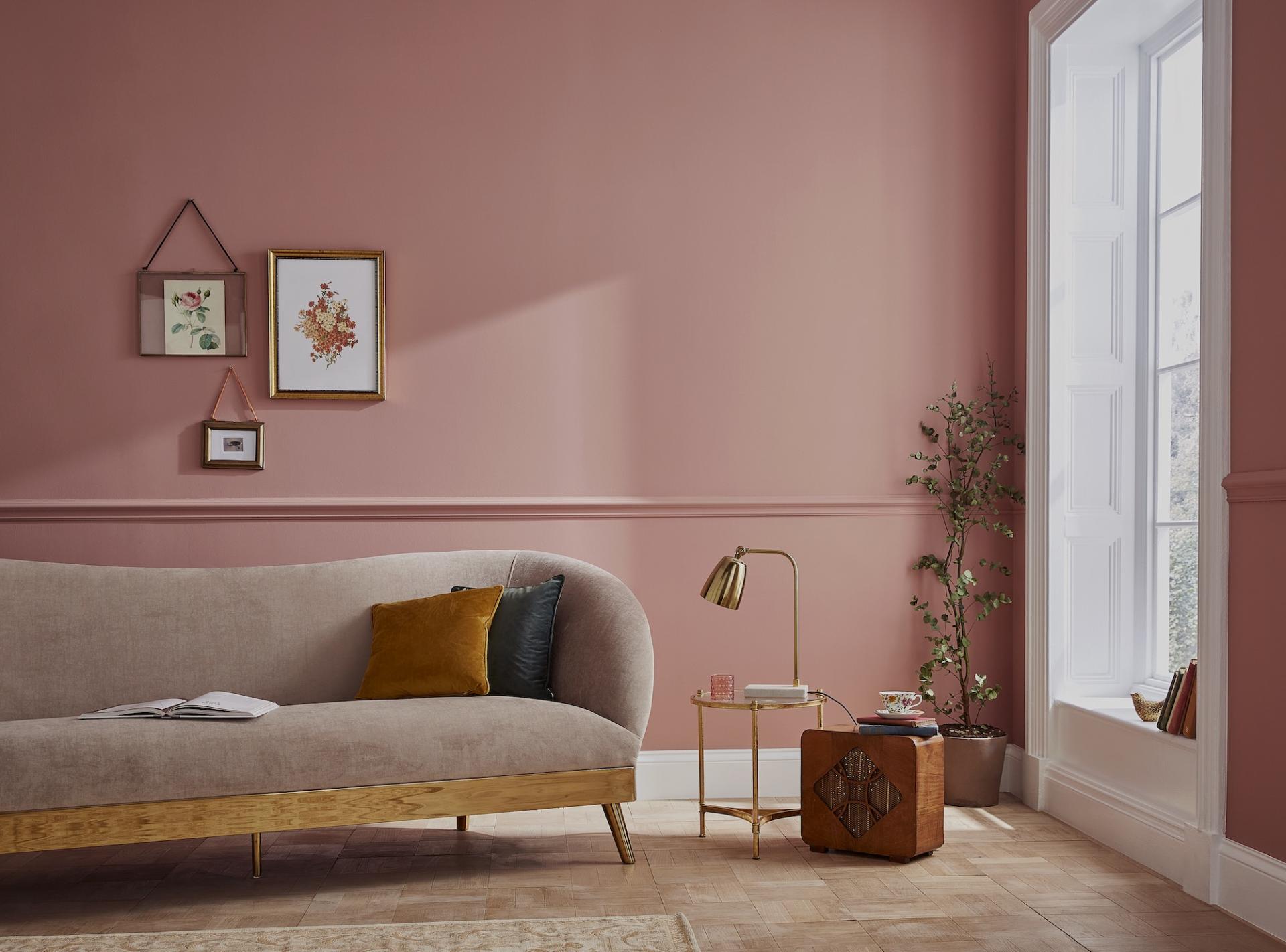 Stylish living room featuring a blush pink wall, modern sofa, and curated home decor elements for 2021.