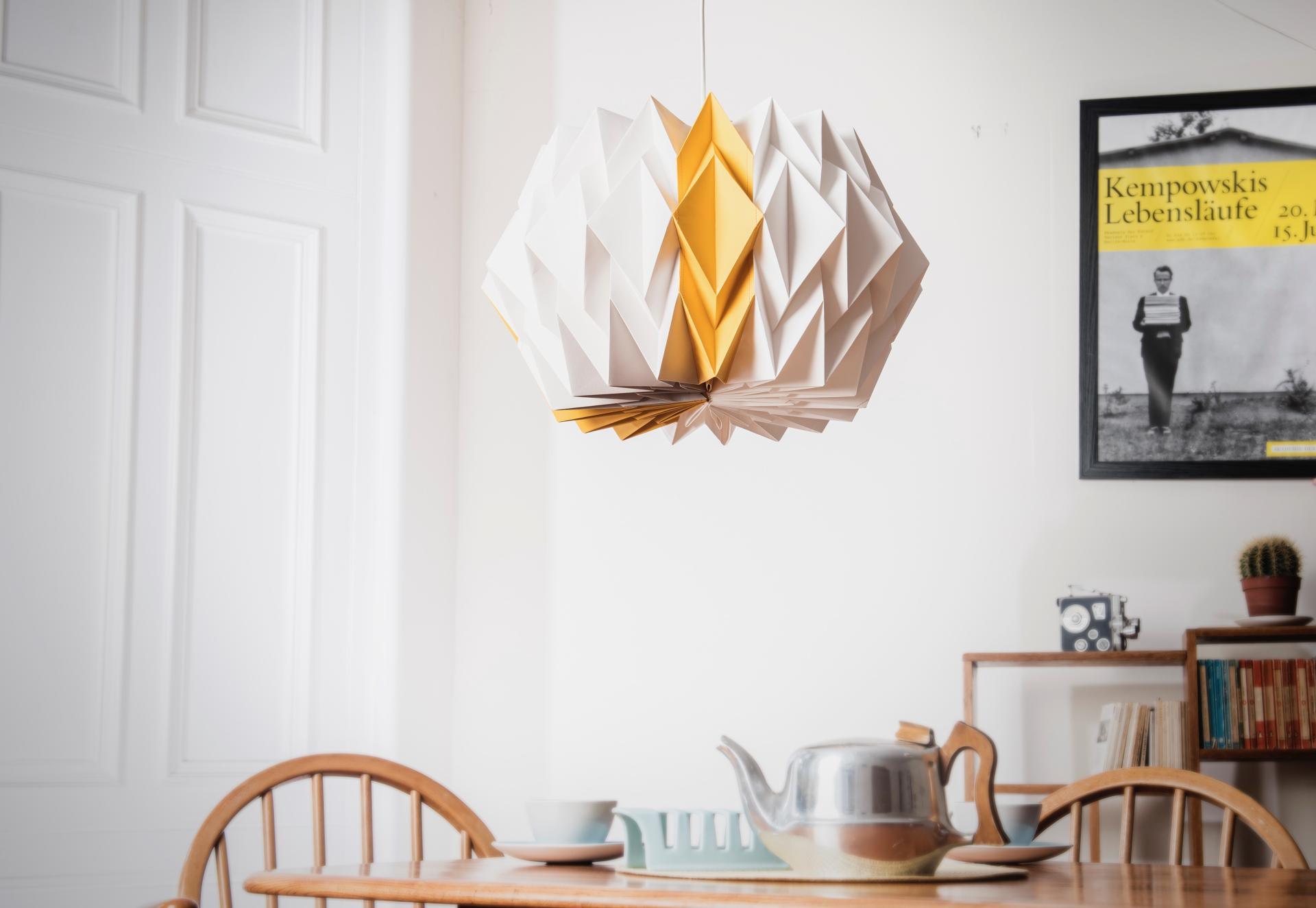 Unique origami-style pendant light above a wooden dining table, showcasing Glasgow's creative craft aesthetic.