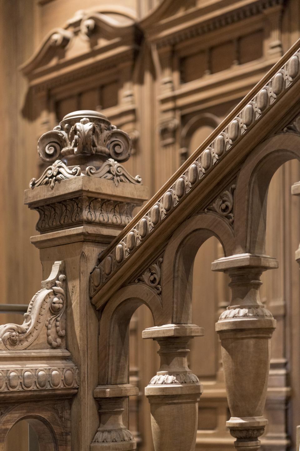 Intricate wooden stair railing showcases classic Parisian architecture in Apple’s Champs-Élysées store designed by Foster + Partners.