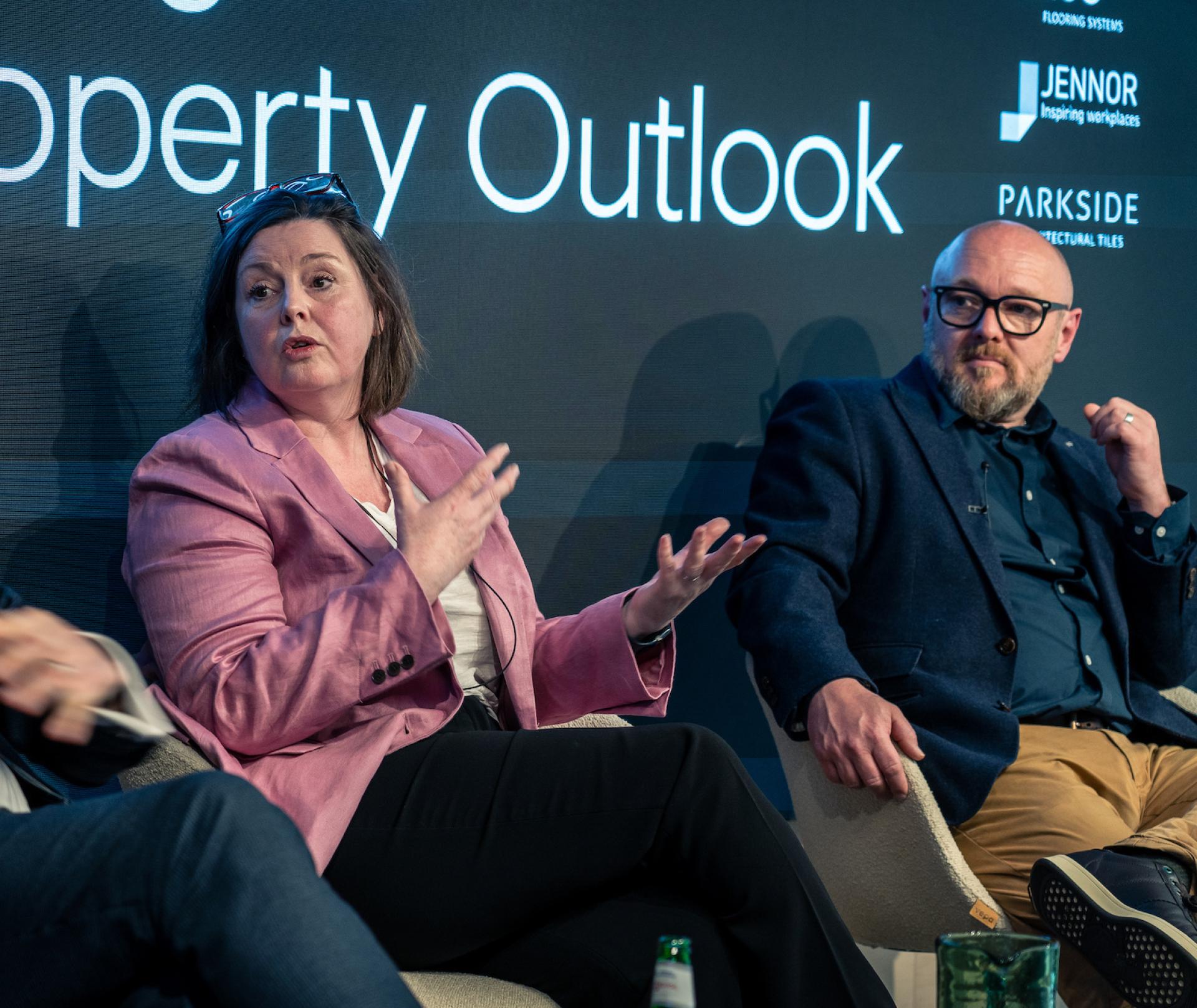 Discussion panel on Glasgow's property outlook featuring two speakers engaged in conversation.