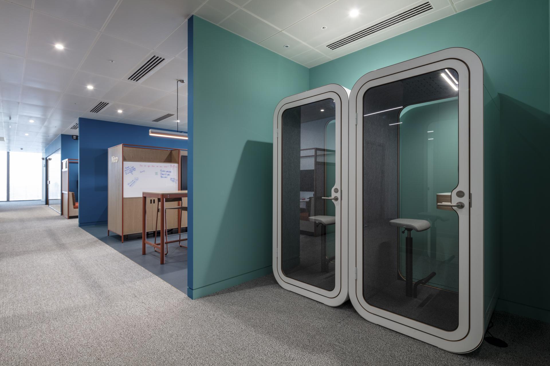 Modern office space at 22 Bishopsgate featuring private soundproof booths and collaborative work areas in vibrant colors.