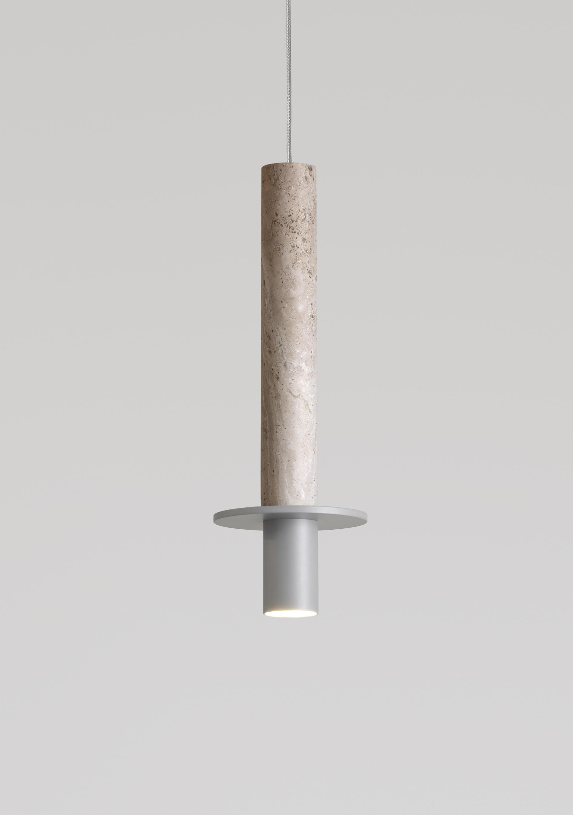Pendant light featuring a textured stone column and a sleek metal base, representing the Meta collection's new finishes.