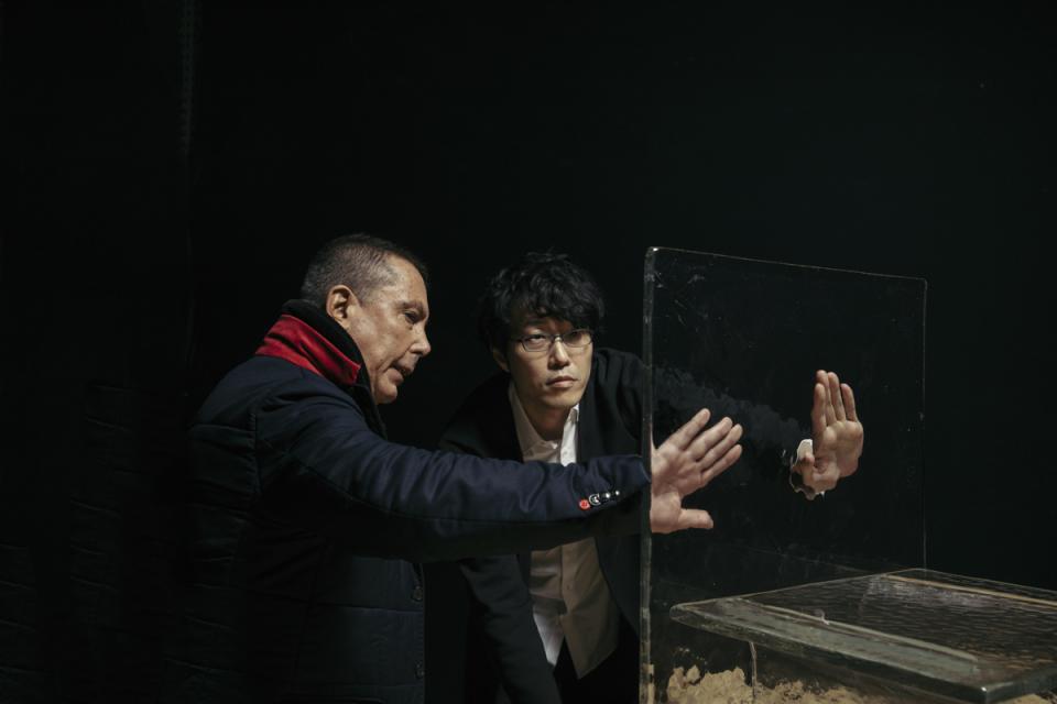 Two designers collaborate around a transparent case, exploring cast glass furniture concepts for the Melt collection.