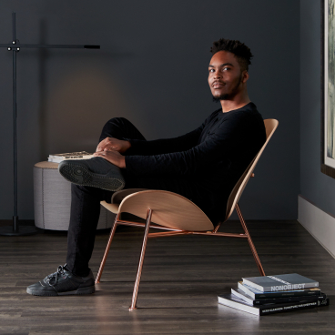Pedersen lounge chair by Thomas Pedersen, showcasing modern design with a seated individual in a stylish setting.