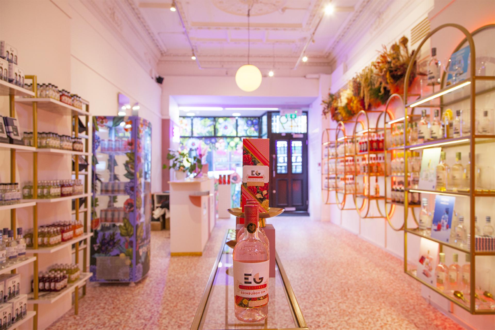 Bright interior of an Edinburgh Gin pop-up store featuring colorful bottles, terrazzo flooring, and vibrant decor.