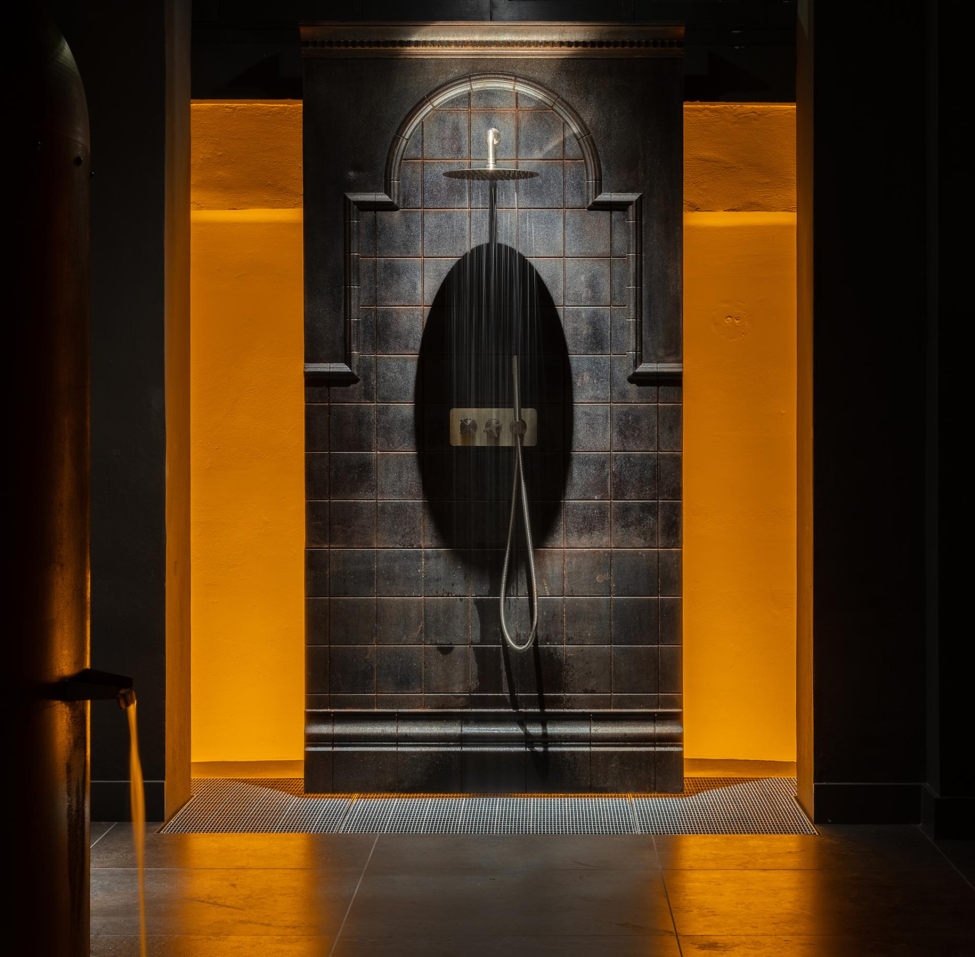 Elegant shower installation in Holloway Li's new showroom, featuring textured tiles and vibrant lighting in Clerkenwell.