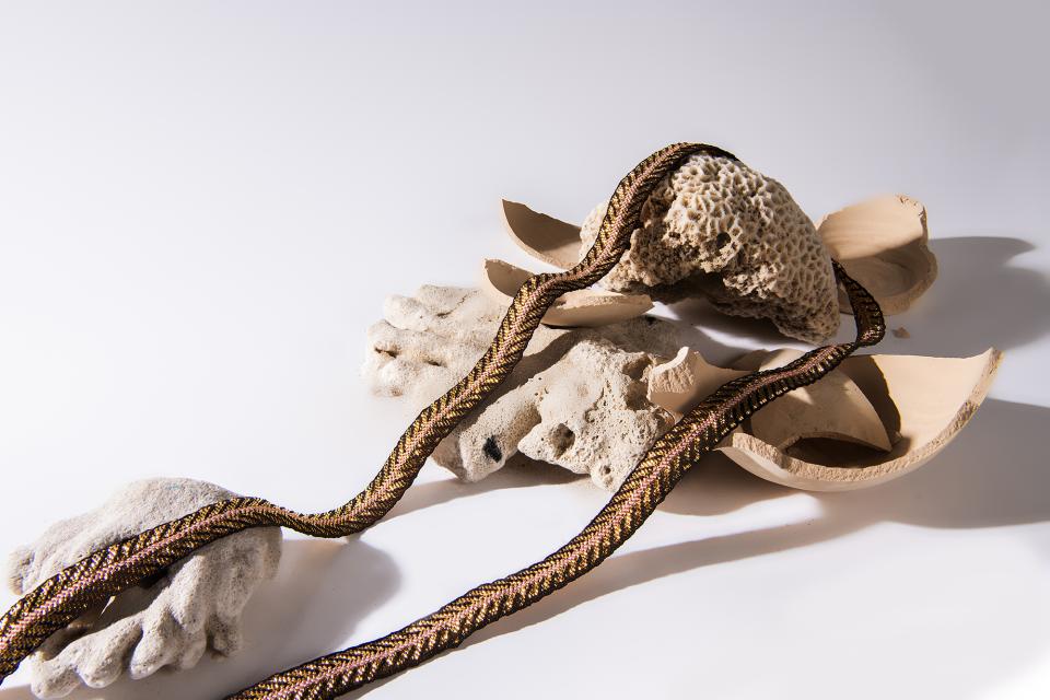 Artistic display of sculptural design elements, including textured coral pieces and braided textile, reflecting contemporary craftsmanship.