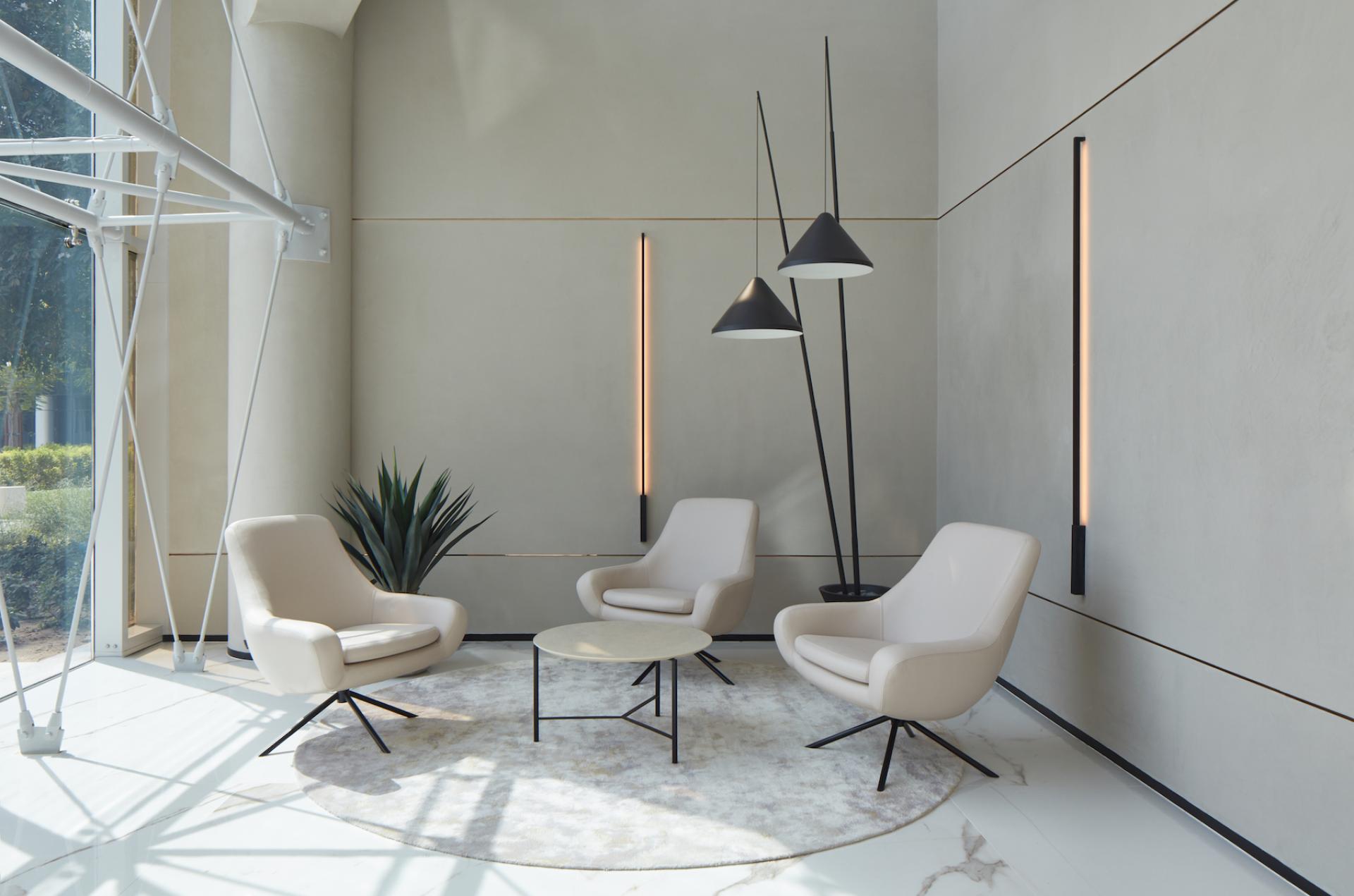 Modern management office seating area in Dubai Internet City, featuring stylish chairs, a round table, and contemporary lighting.