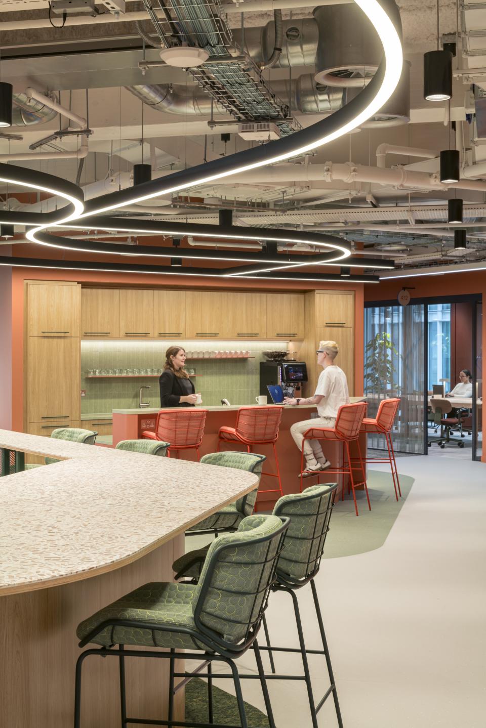 Modern office interior of Virgin Media O2 headquarters featuring collaborative spaces, stylish seating, and vibrant design elements.